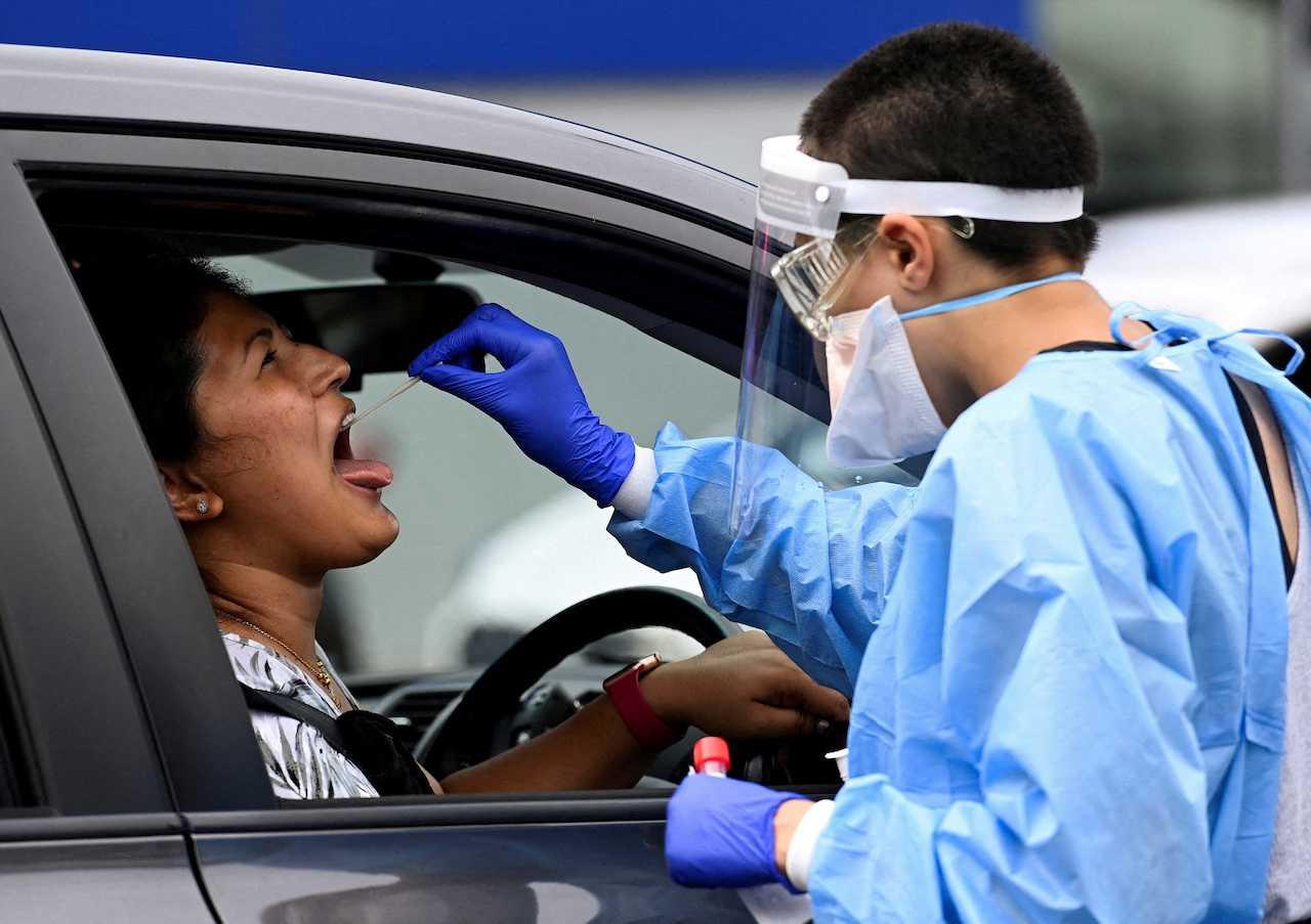 A woman takes a Covid-19 test at a testing centre in Sydney, Australia, Jan 5, 2022. Photo: Reuters