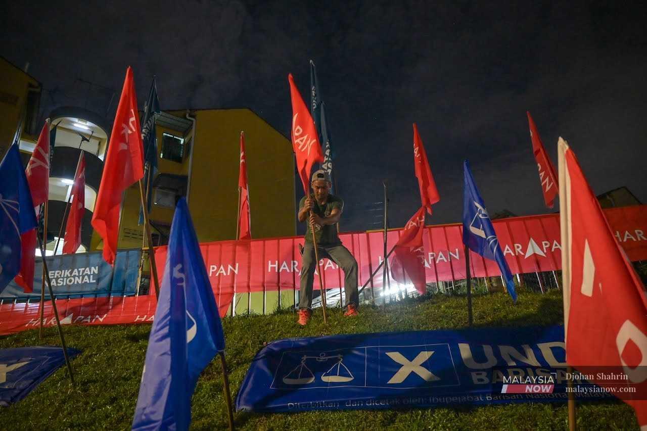 Election workers put up party flags at Taman Keramat Permai in Kuala Lumpur ahead of the 15th general election on Nov 7, 2022.