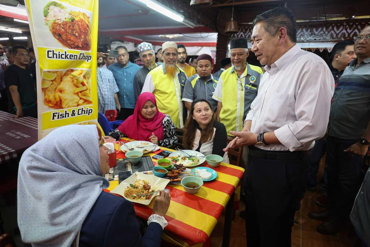 Domestic Trade and Cost of Living Minister Salahuddin Ayub chats with customers at an eatery participating in the Menu Rahmah initiative in Kuala Lumpur, Feb 8. Photo: Bernama