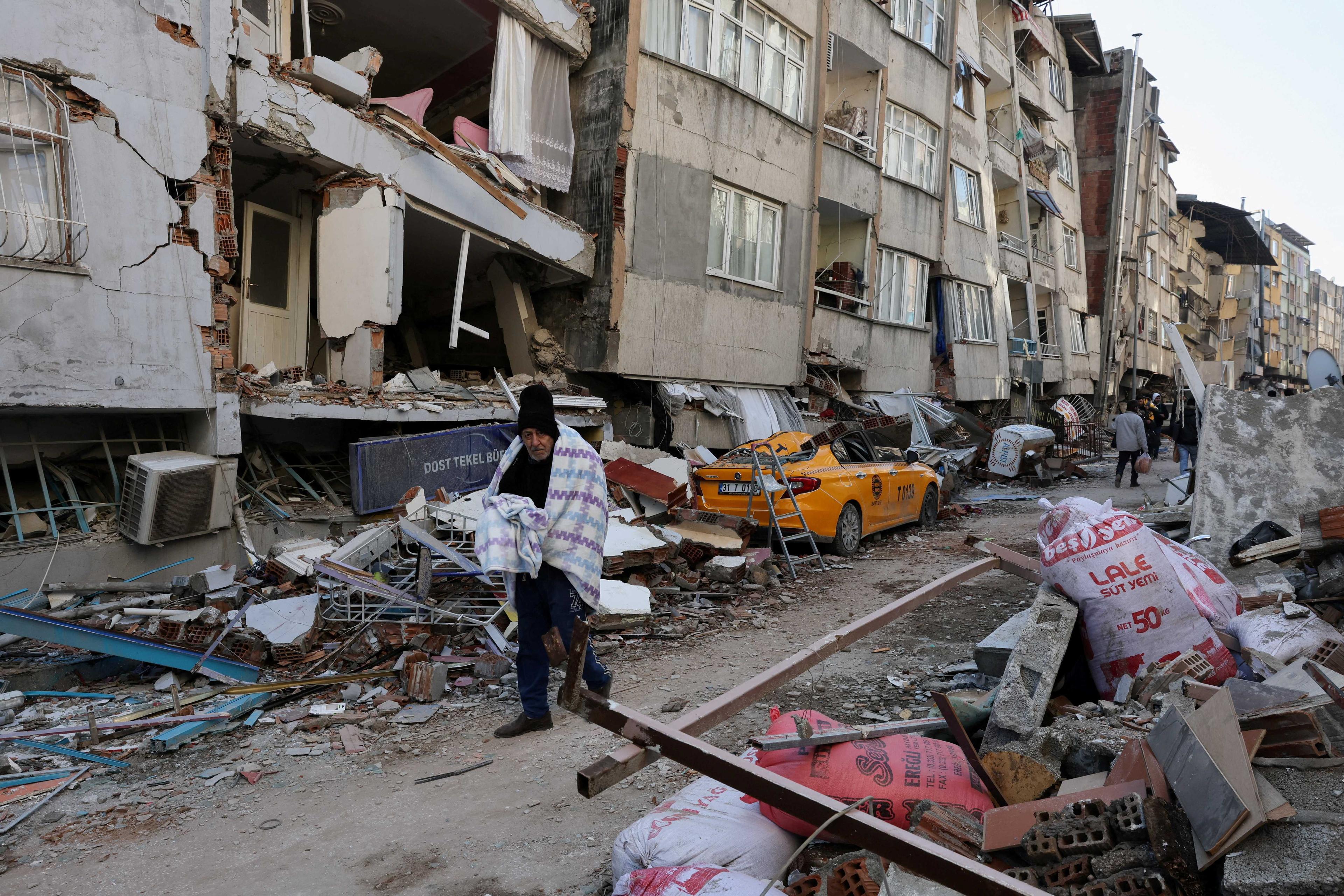 Seorang lelaki berjalan melepasi bangunan runtuh ketika pencarian mangsa yang terselamat diteruskan berikutan gempa bumi dahsyat di Hatay, Turki. 9 Februari. Gambar: Reuters