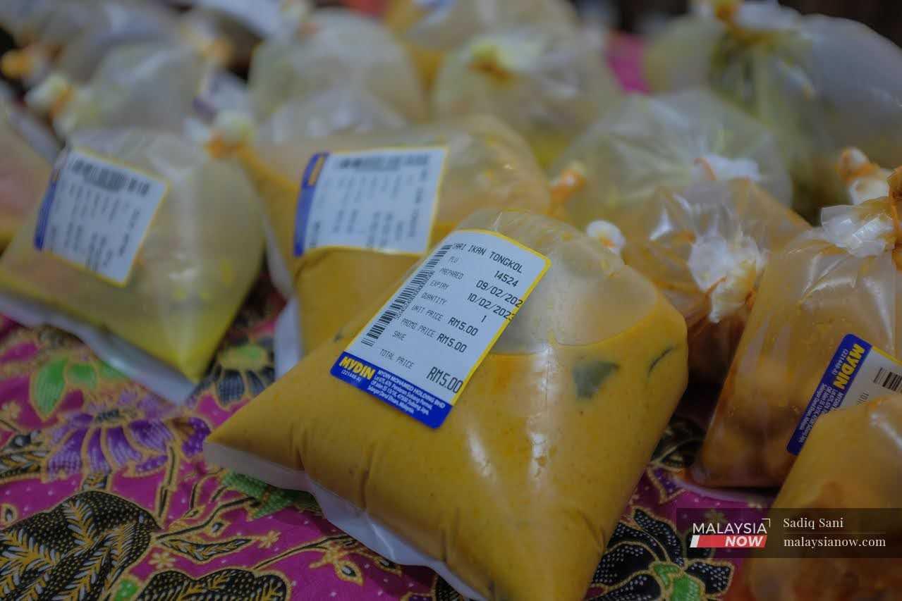 Packets of fish curry, priced at RM5 each, are prepared for sale under the government's Menu Rahmah programme.