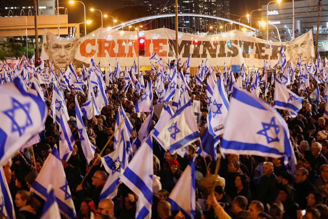 People hold Israeli flags during a protest against Prime Minister Benjamin Netanyahu's new right-wing coalition and its proposed judicial reforms to reduce powers of the Supreme Court in Tel Aviv, Israel, Feb 11. Photo: Reuters