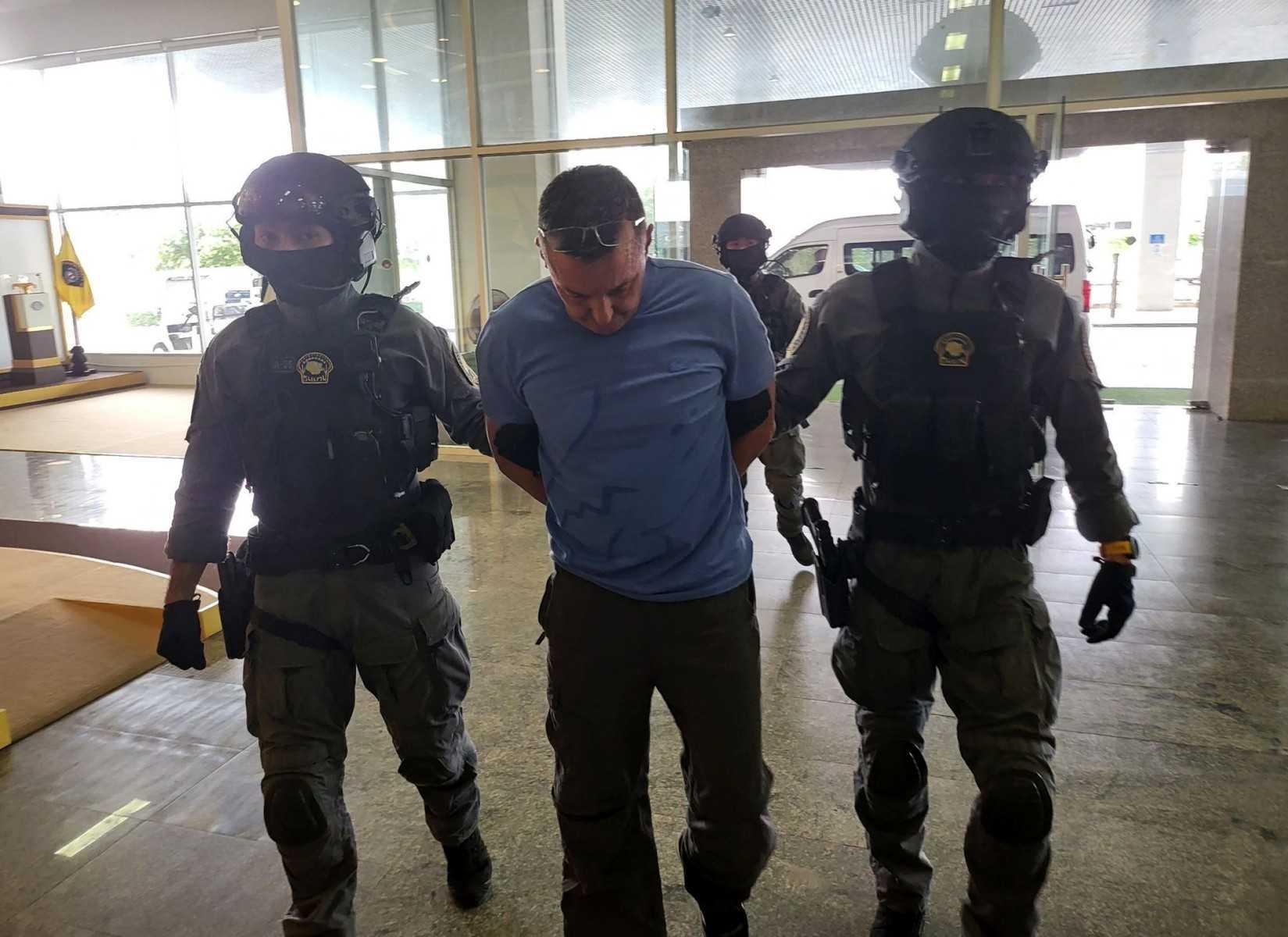 A handout picture released by Britain's National Crime Agency (NCA) in London on Feb 12, shows Richard Wakeling being arrested by members of the Royal Thai Police in Bangkok on Feb 10. Photo: AFP