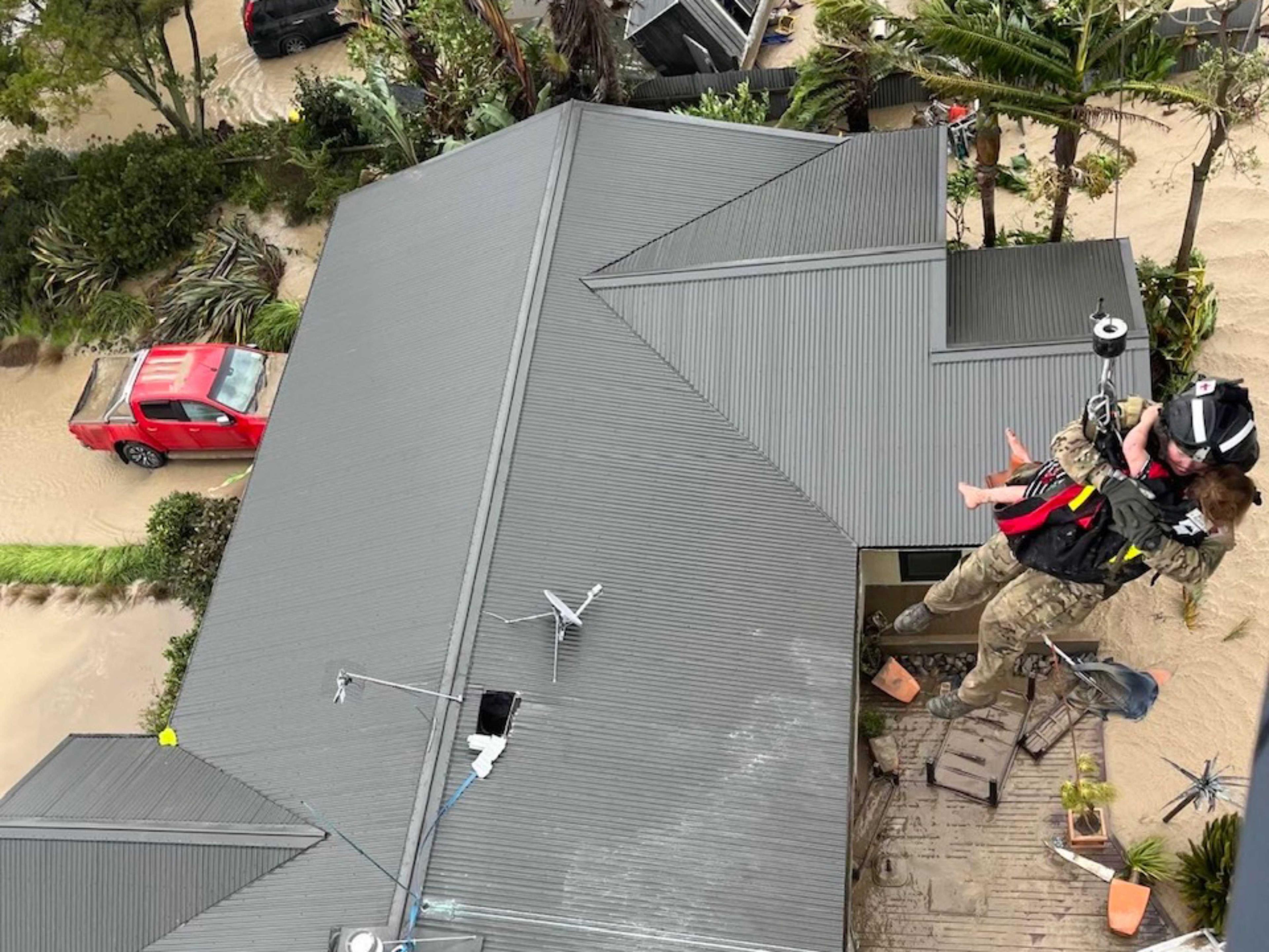 A handout photo taken and received on Feb 14, from the New Zealand Defence Force shows stranded people being air lifted from their rooftop by a military helicopter in the Esk Valley, near the North Island city of Napier. Photo: AFP