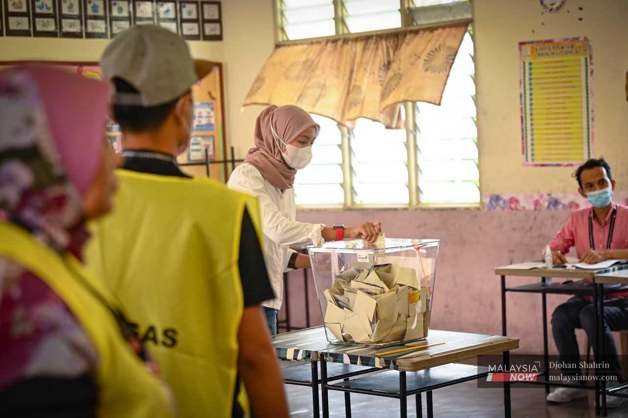 A woman casts her ballot at a voting centre in Kampung Baru, Kuala Lumpur, at the 15th general election on Nov 19, 2022. 
