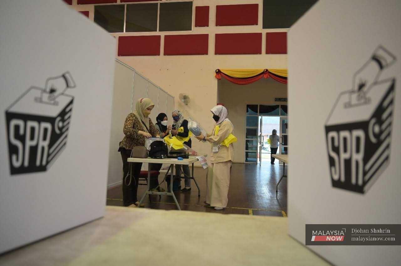 Petugas Suruhanjaya Pilihan Raya melakukan persiapan untuk pengundian awal Pilihan Raya Negeri Sarawak di pusat mengundi Kem Muara Tuang, Kota Samarahan, 13 Disember 2021.