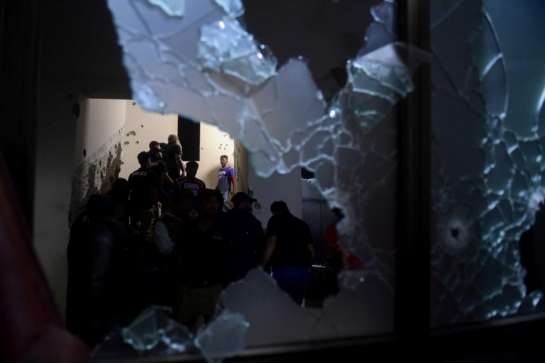 Security personnel and volunteers are seen through a shattered window as they inspect a police compound after taking control of the building, following an attack by Pakistani Taliban fighters, in Karachi on Feb 17. Photo: AFP