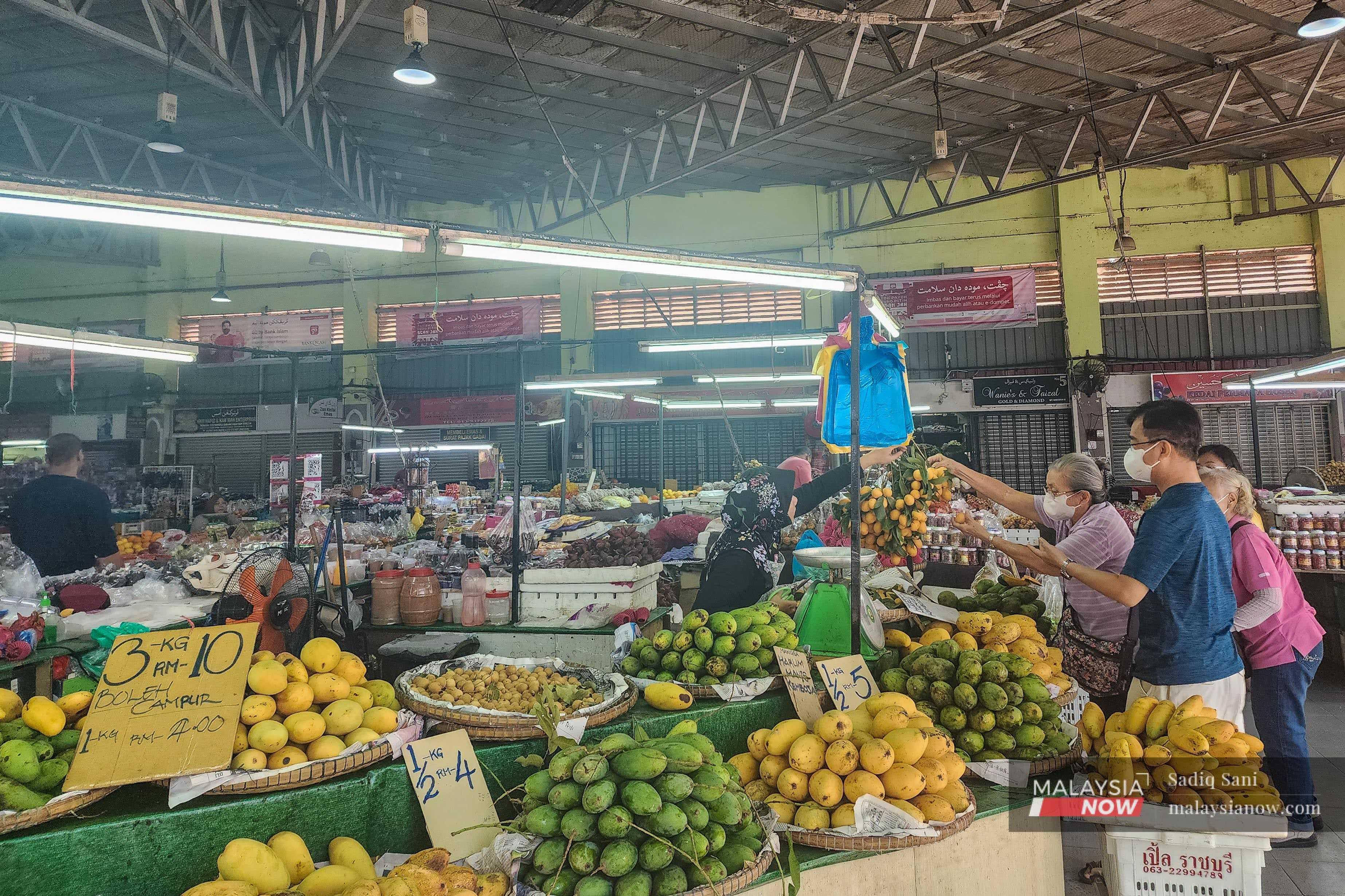 Pelanggan membeli buah-buahan di Pasar Siti Khadijah, Kota Baharu, Kelantan.