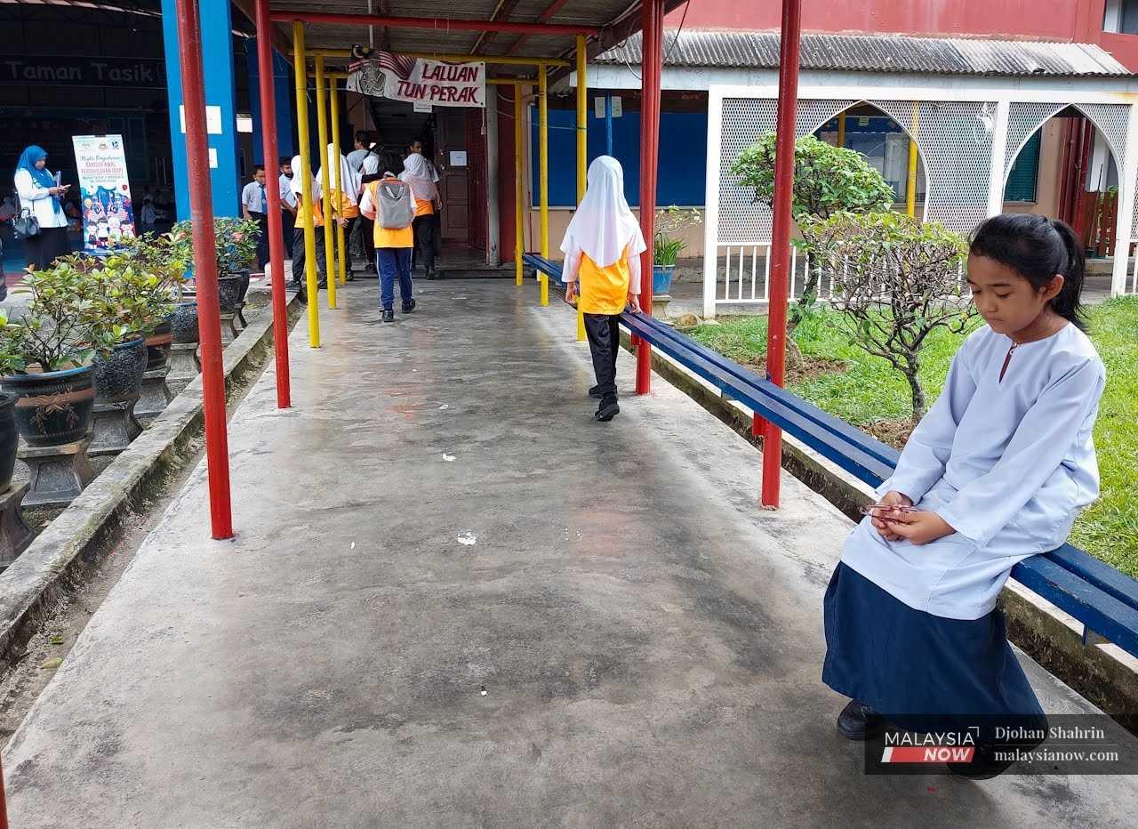 Seorang murid sedang duduk di ruang legar sekolah, 19 Januari.