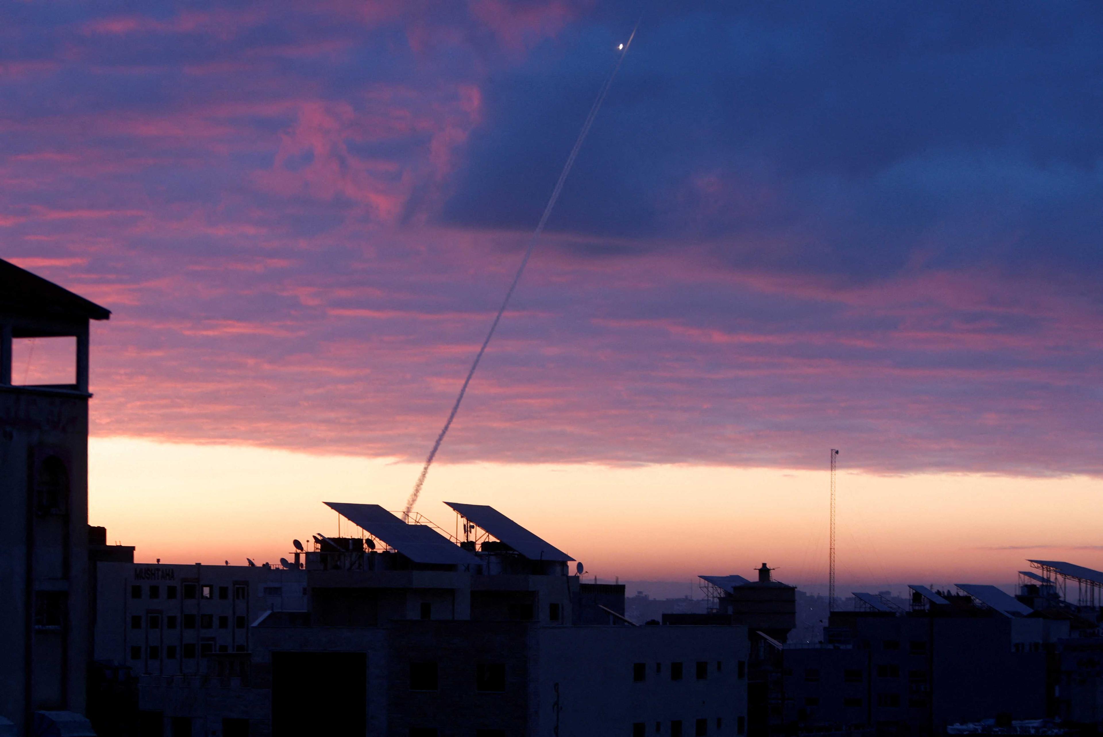 Trails of smoke are seen as rockets are fired from Gaza towards Israel during the sunrise, in Gaza City Feb 23. Photo: Reuters