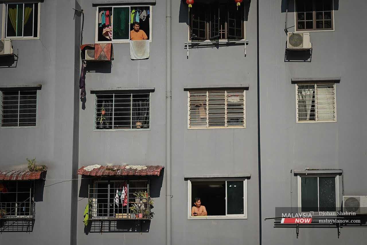 Kelihatan dua penduduk pangsapuri Sri Penara melihat ke luar ketika Perintah Kawalan Pergerakan Diperketatkan (PKPD) angkara Covid-19 di Cheras, Kuala Lumpur pada 3 Jun 2021.