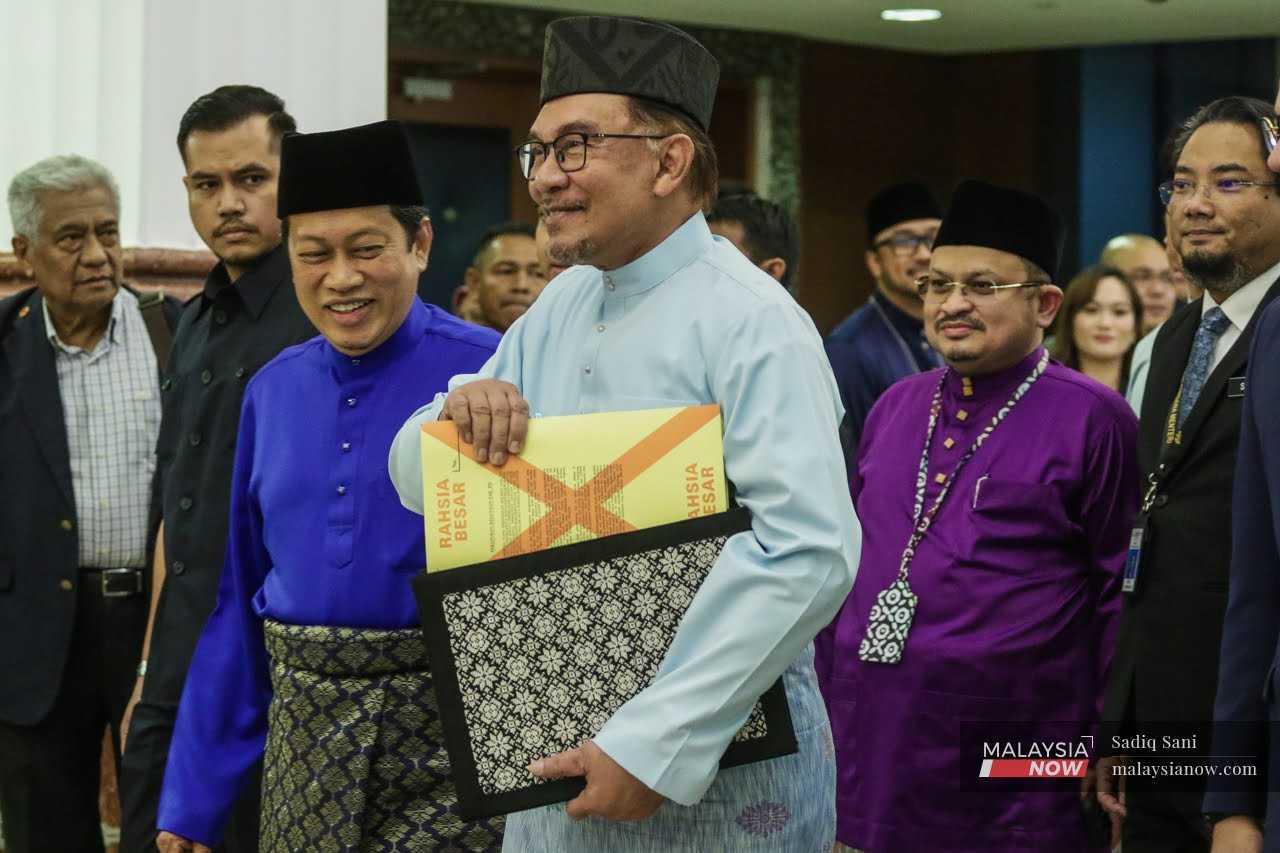 Prime Minister Anwar Ibrahim, flanked by his deputy finance ministers Ahmad Maslan and Steven Sim, ahead of the budget presentation, Feb 24.