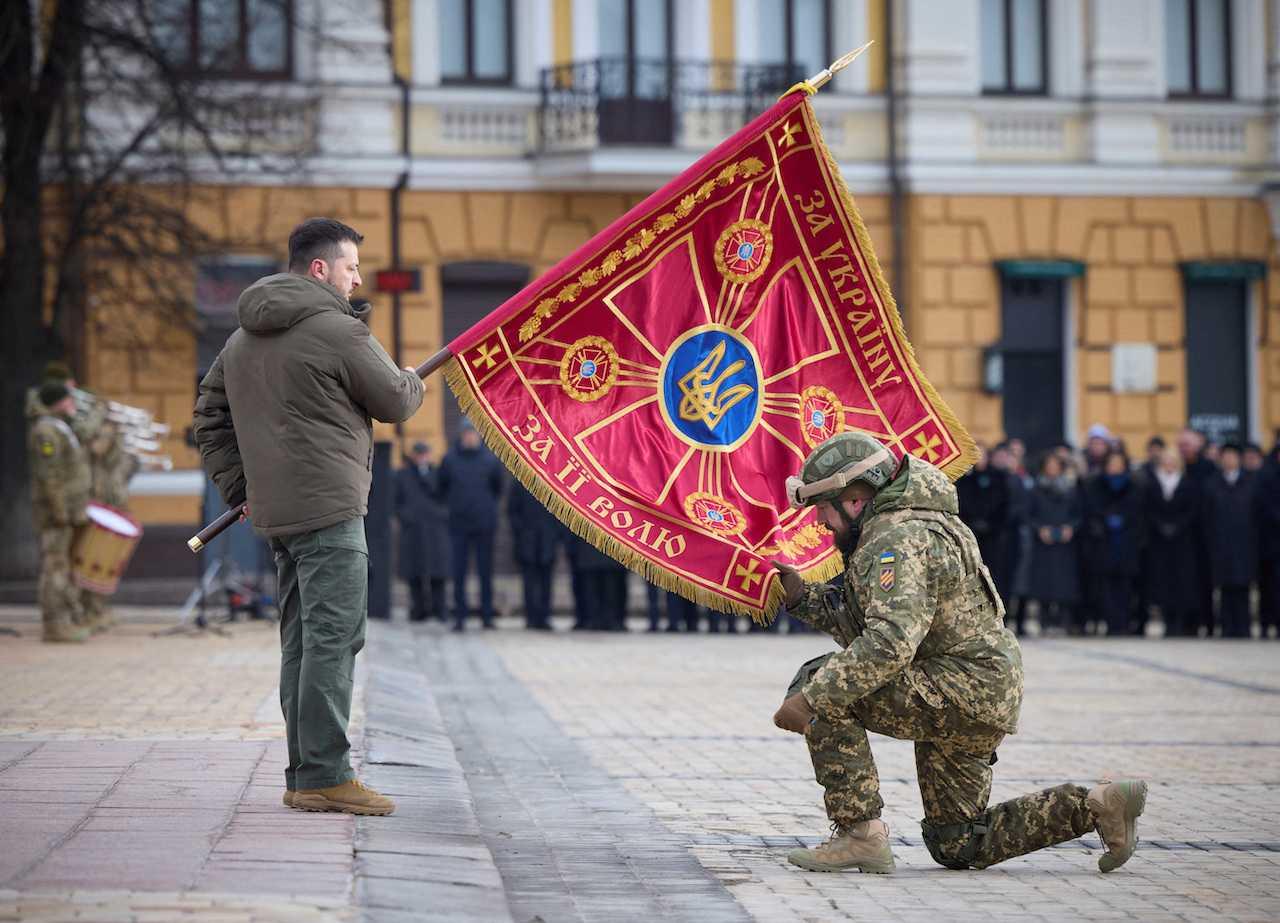 Ukraine's President Volodymyr Zelensky hands over a flag to a serviceman during a ceremony dedicated to the first anniversary of the Russian invasion of Ukraine, in Kyiv, Ukraine, Feb 24. Photo: Reuters