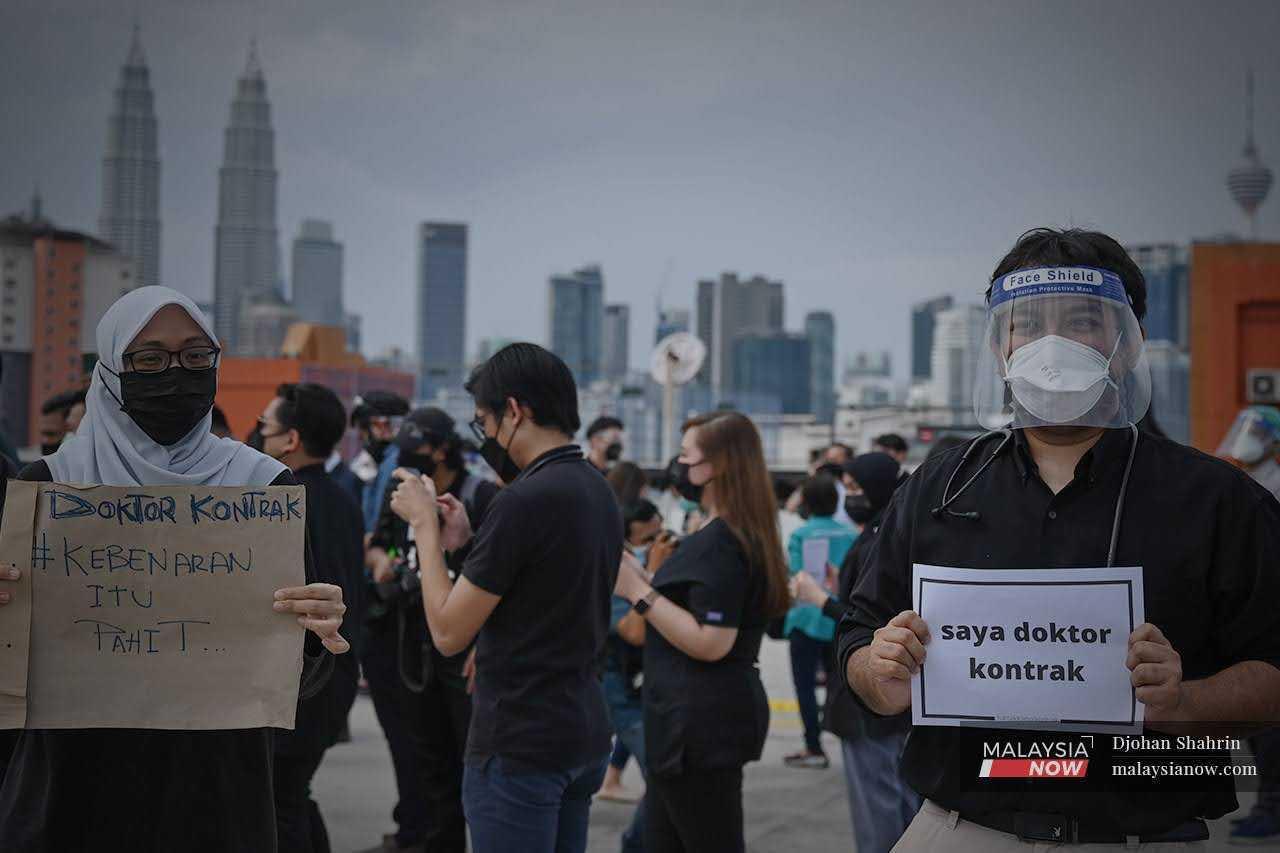 Contract doctors at Hospital Kuala Lumpur hold up placards during a walkout in 2021. 
