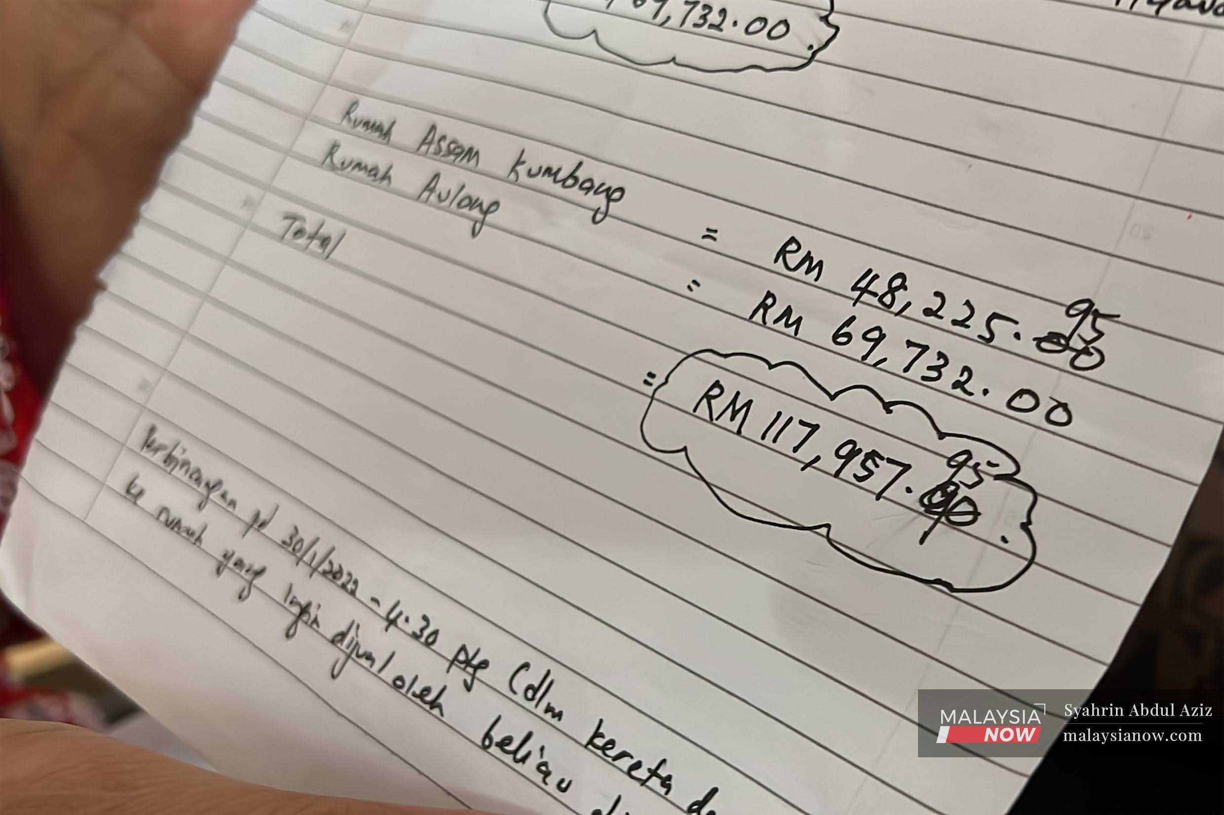 Seorang guru memegang sehelai kertas yang menunjukkan bayaran dibuatnya kepada seorang wanita didakwa menipu orang ramai membabitkan jumlah ratusan ribu ringgit dalam penipuan hartanah di Taiping, Perak.
