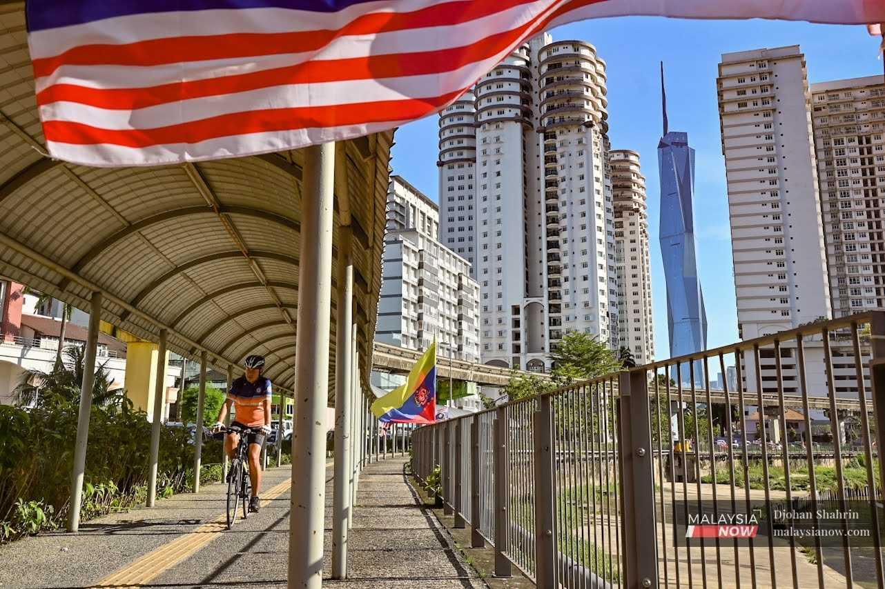 A man cycles beneath a roofed walkway at Brickfields, Kuala Lumpur.