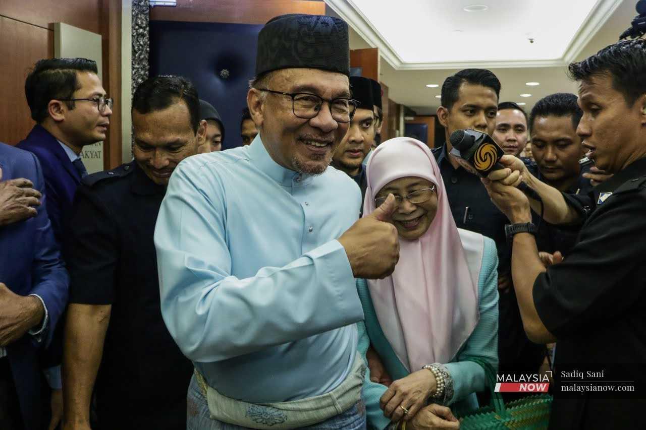 Perdana Menteri Anwar Ibrahim ditemani isterinya Wan Azizah Wan Ismail keluar dari bangunan Parlimen selepas membentangkan Belanjawan 2023 pada 24 Februari.
