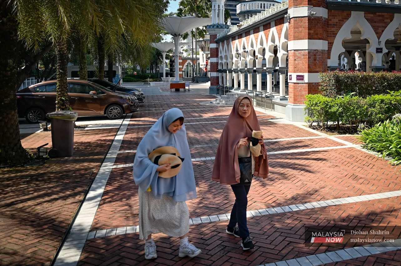 Dua pelancong dari Jepun memakai tudung ketika melawat kawasan sekitar Masjid Jamek, Kuala Lumpur pada 16 Februari.