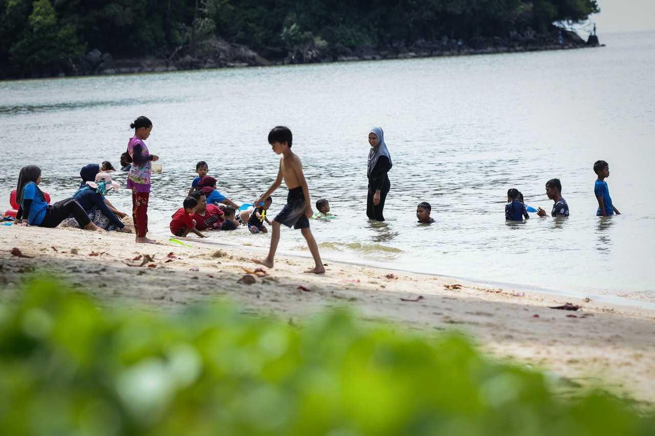Families enjoy a day at the beach at Teluk Bayu in George Town, Penang. Photo: Bernama