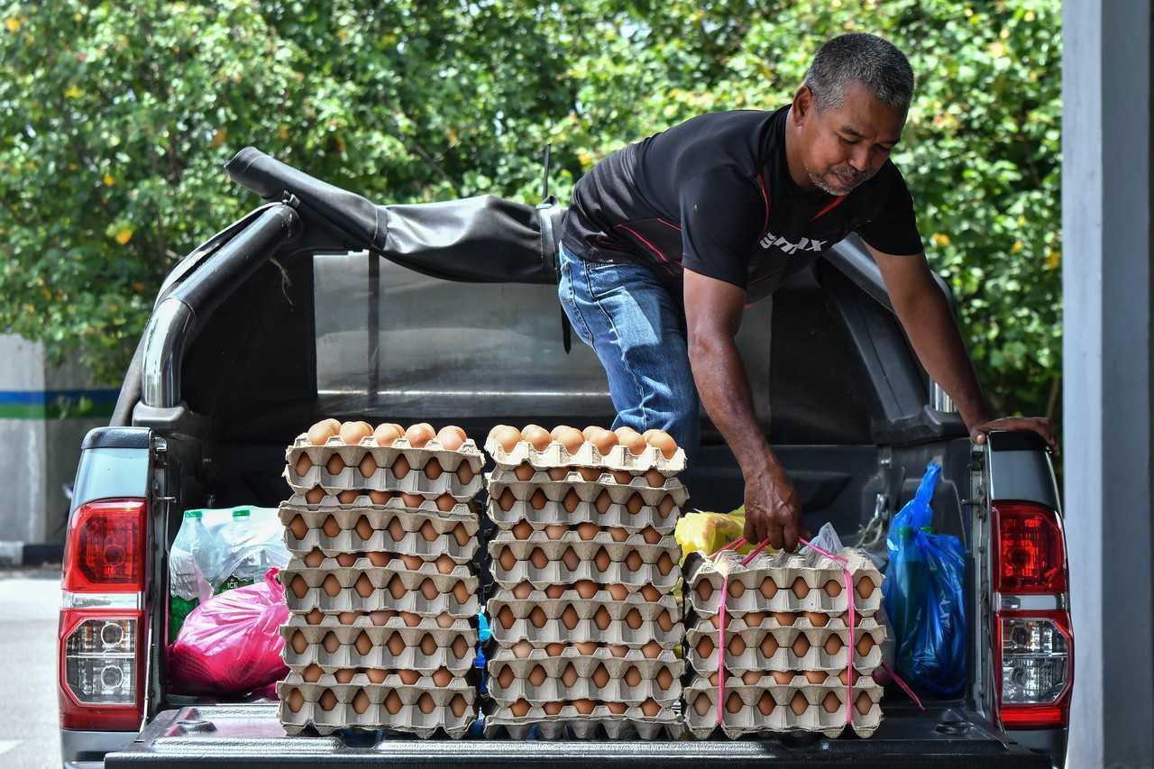Peruncit Mat Yazid Hitam, 54, mendapatkan bekalan telur ayam yang terhad daripada pemborong untuk dijual kepada pelanggannya di Chabang Tiga, 25 September 2022. Gambar: Bernama
