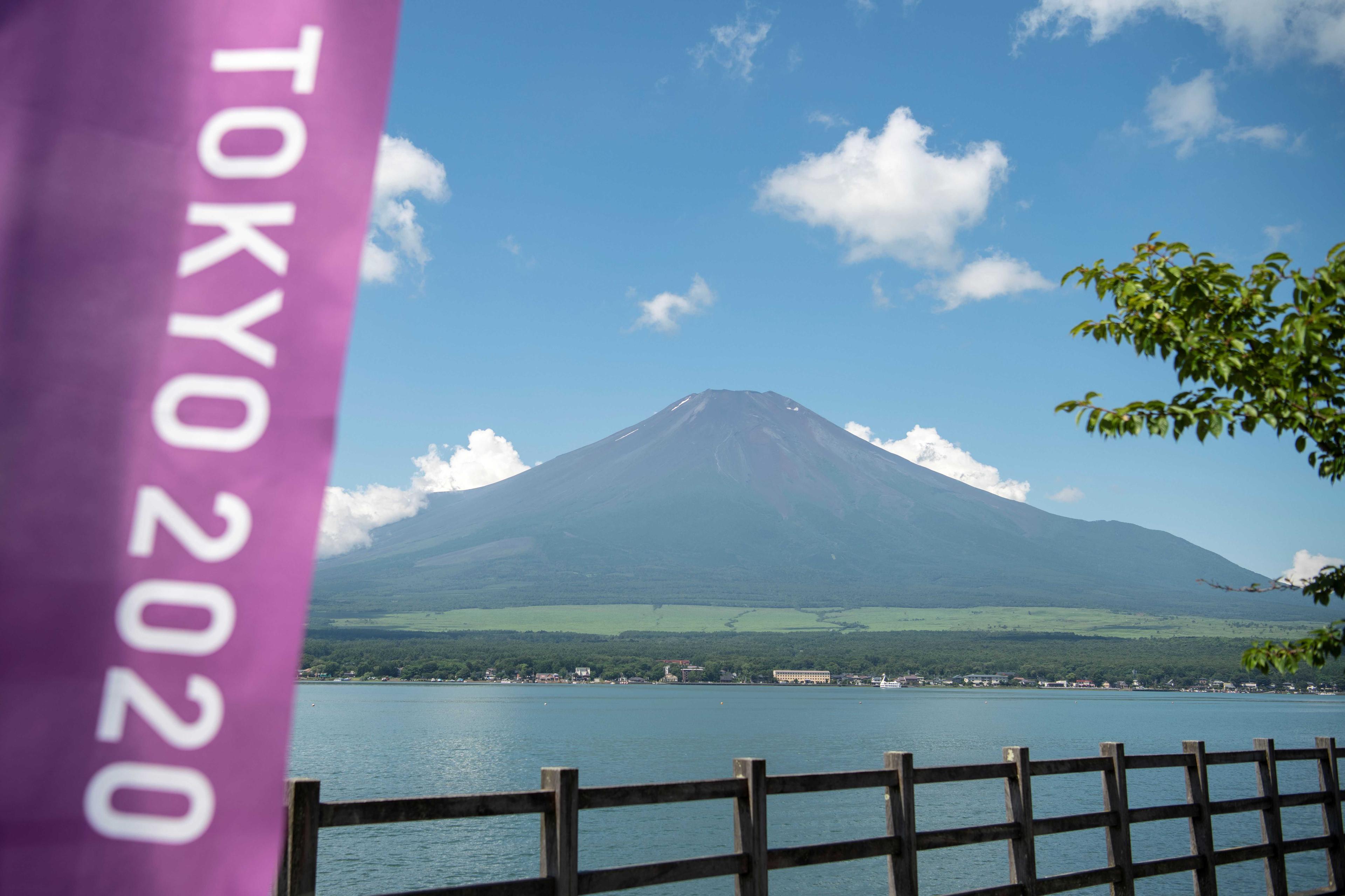 This general view shows Mount Fuji, Japan's highest mountain at 3,776 meters, seen from Lake Yamanaka, next to a Tokyo 2020 Olympics banner on July 19, 2021. Photo: AFP 