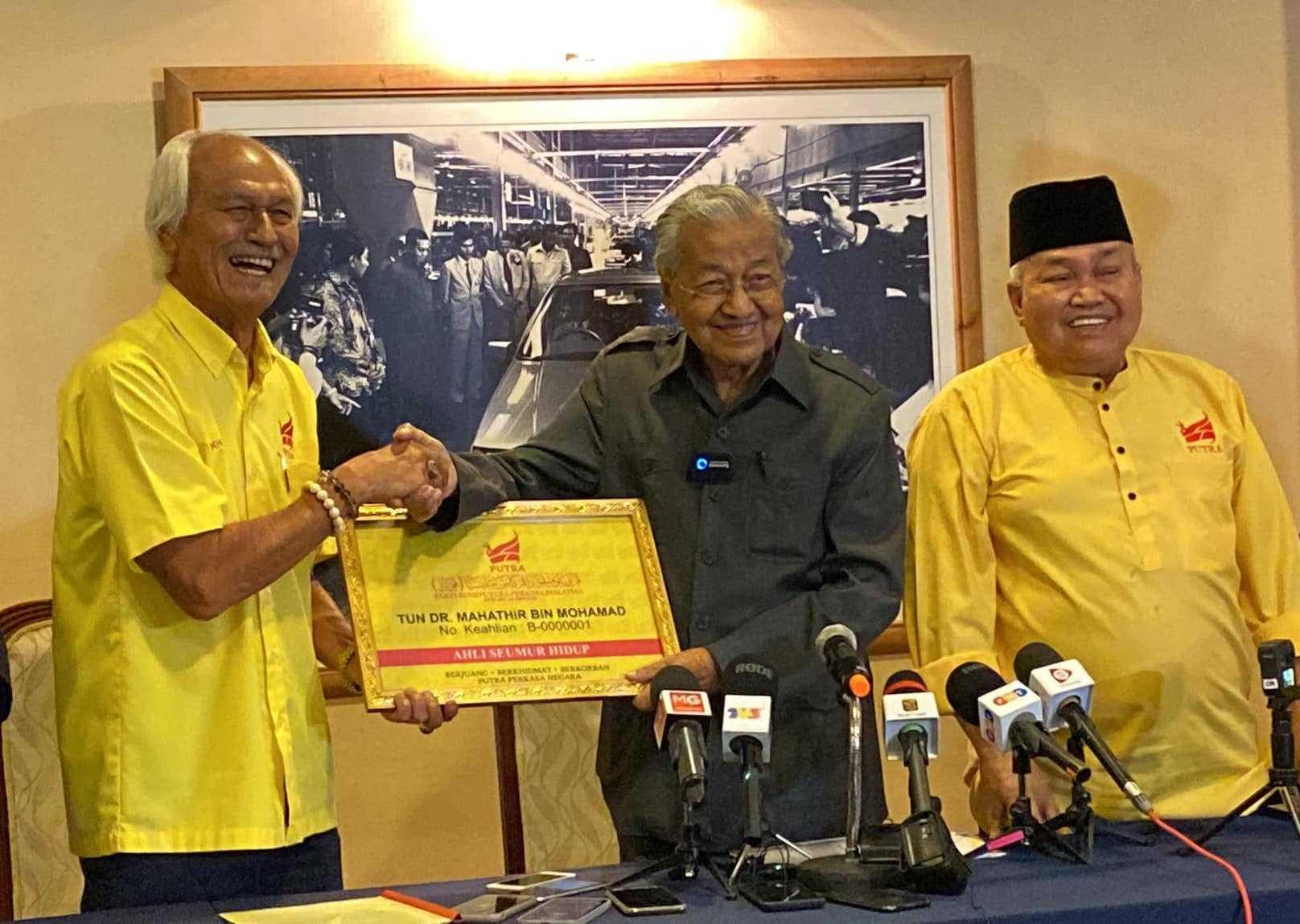 Dr Mahathir Mohamad berjabat tangan dengan Timbalan Presiden Putra Mohd Khalid Yunus sebagai tanda rasmi menyertai parti pimpinan Ibrahim Ali (kanan) itu. Gambar: Facebook