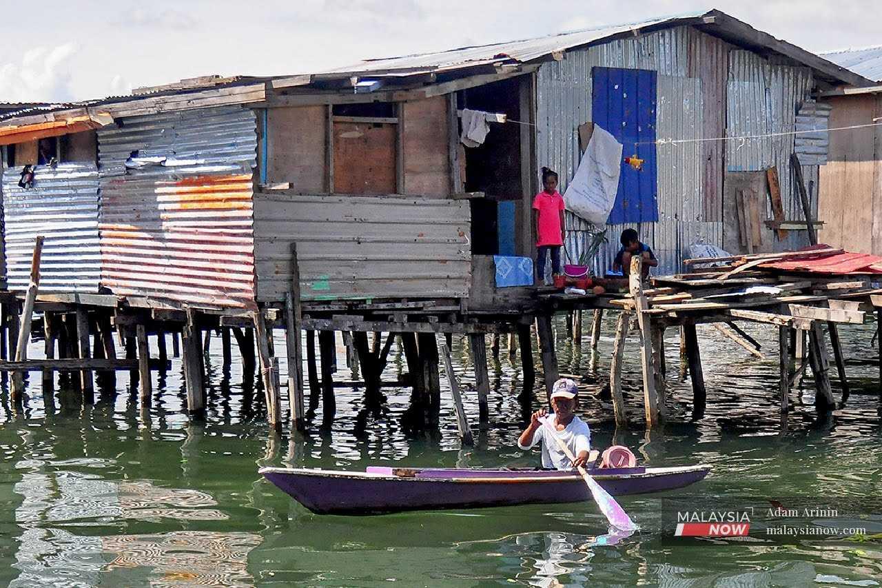 Seorang kanak-kanak mendayung sampan berdekatan perkampungan atas air di Kampung Pondo, Pulau Gaya yang terletak 1.5km dari Kota Kinabalu.