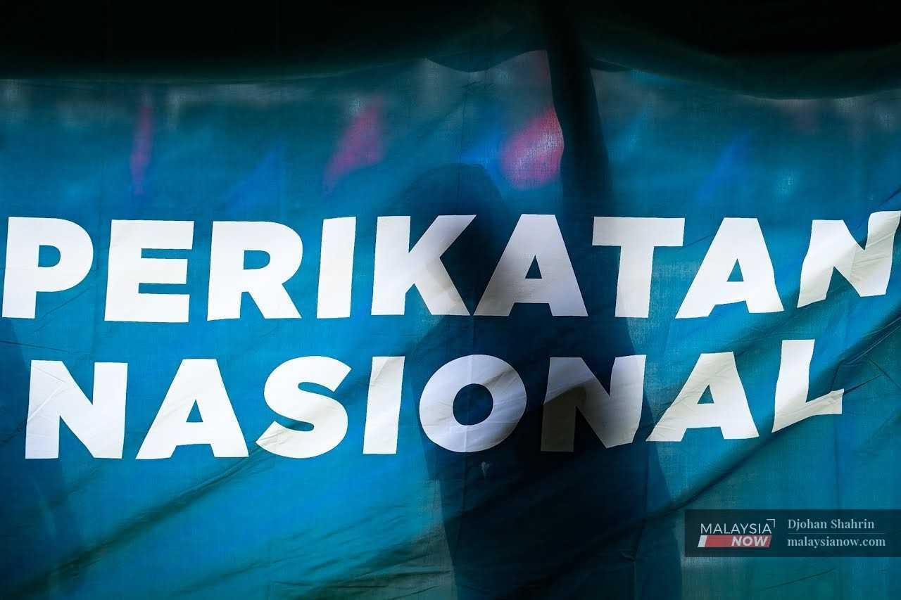 Election workers put up a Perikatan Nasional flag ahead of the 15th general election in November 2022.