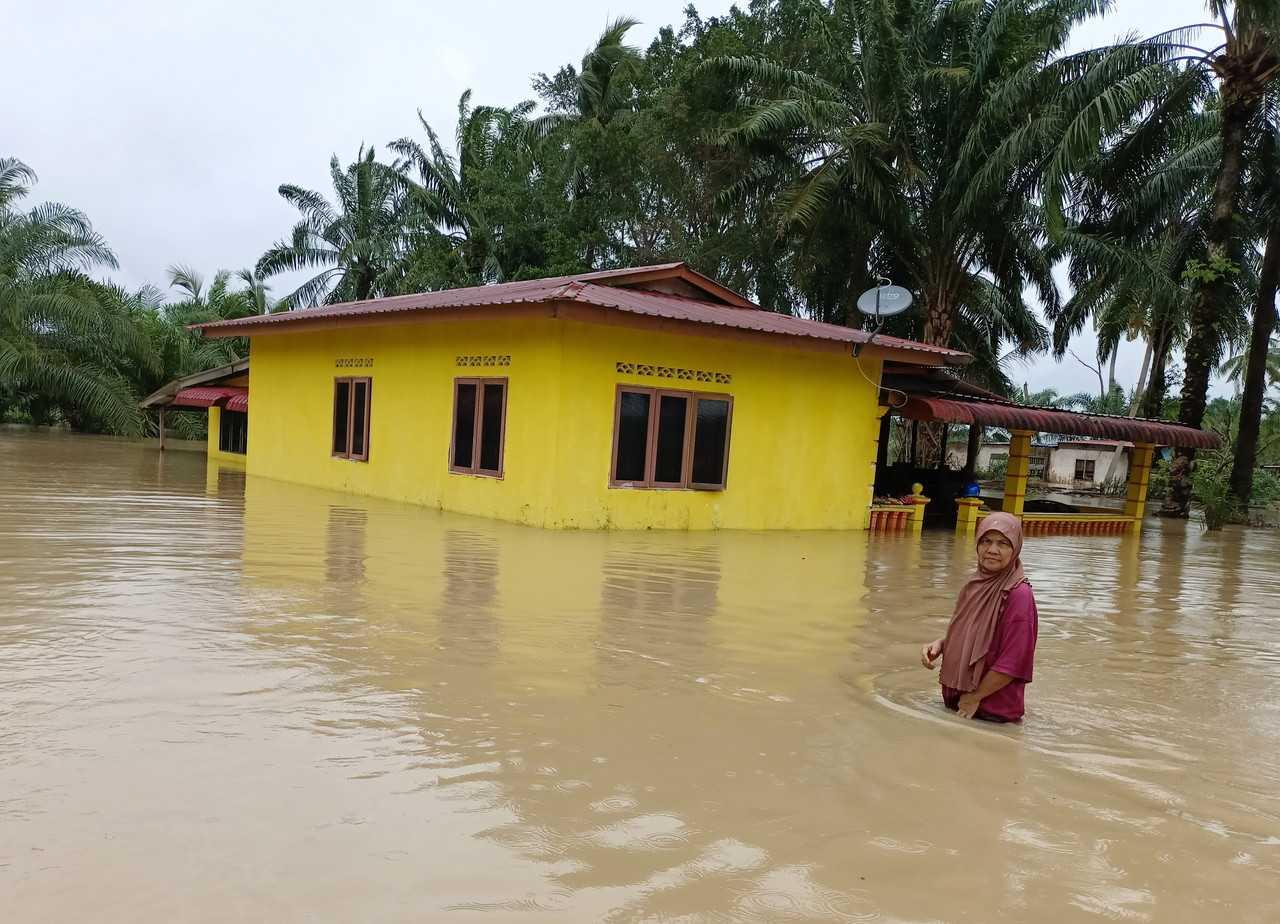A woman stands outside her home in Jasin, Johor, March 3. Photo: Bernama