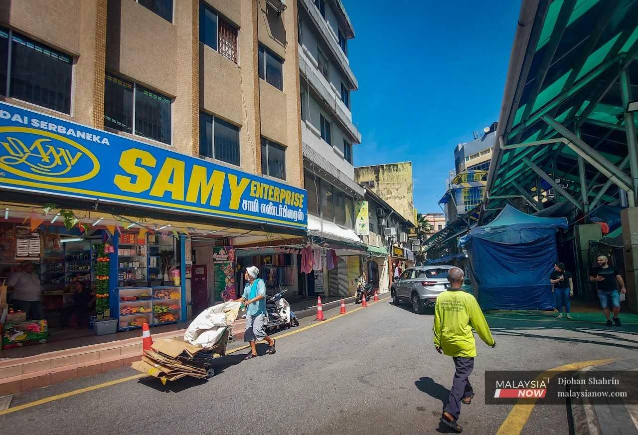 Seorang pemungut kotak dan barangan terbuang mengusung troli hasil kutipannya berhampiran deretan kedai lama di Jalan Melayu, Kuala Lumpur, 16 Februari.