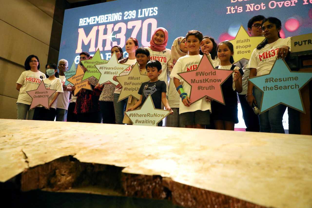 Family members of victims pose for a group picture with some of the debris from missing Malaysia Airlines flight MH370 during its sixth annual remembrance event in Putrajaya, March 7, 2020. Photo: Reuters
