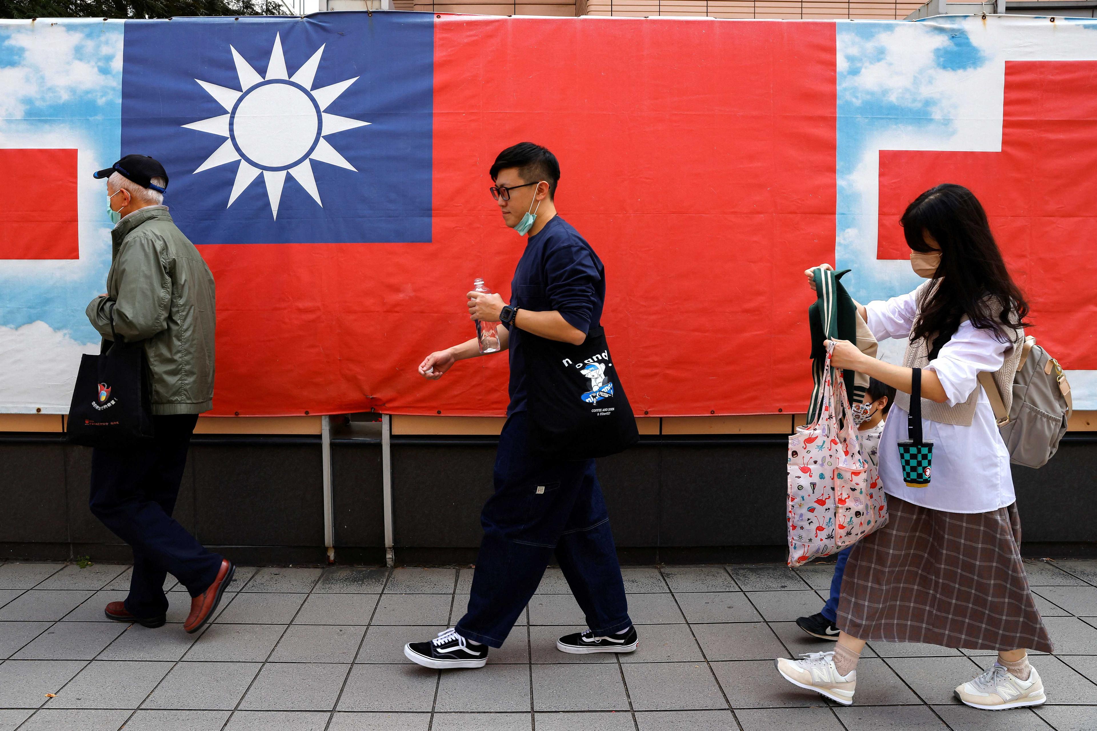 People walk past a Taiwan flag in Taipei, Taiwan, March 7. Photo: Reuters
