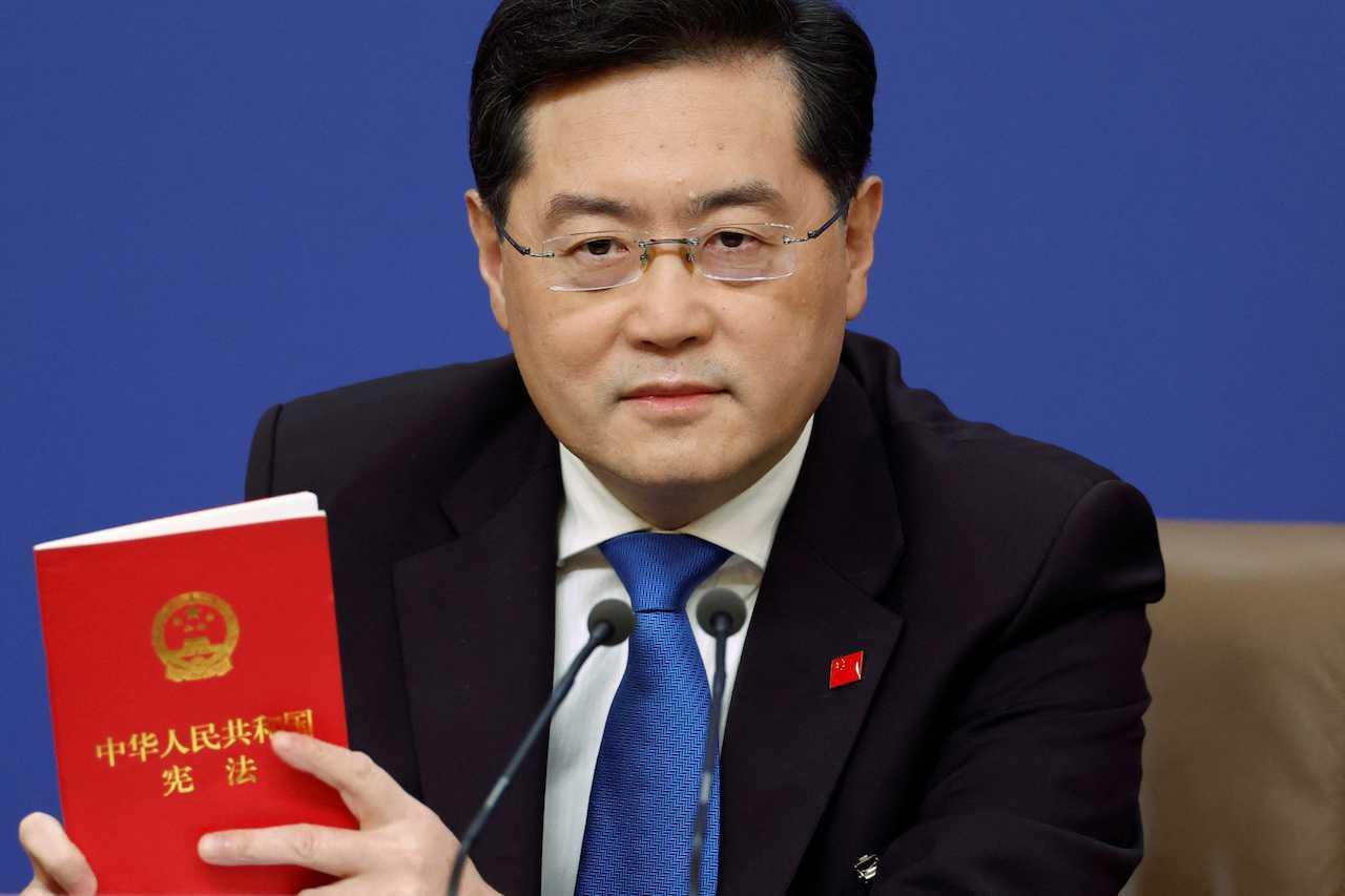 Chinese Foreign Minister Qin Gang holds a book of China's Constitution at a news conference on the sidelines of the National People's Congress in Beijing, March 7. Photo: Reuters