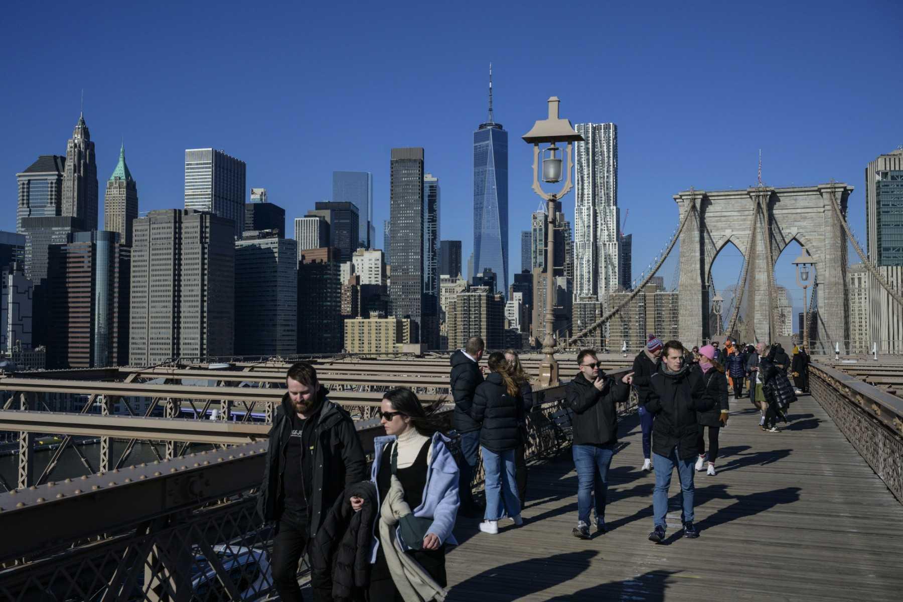 People walk over the Brooklyn Bridge in New York City on Jan 24. Photo: AFP