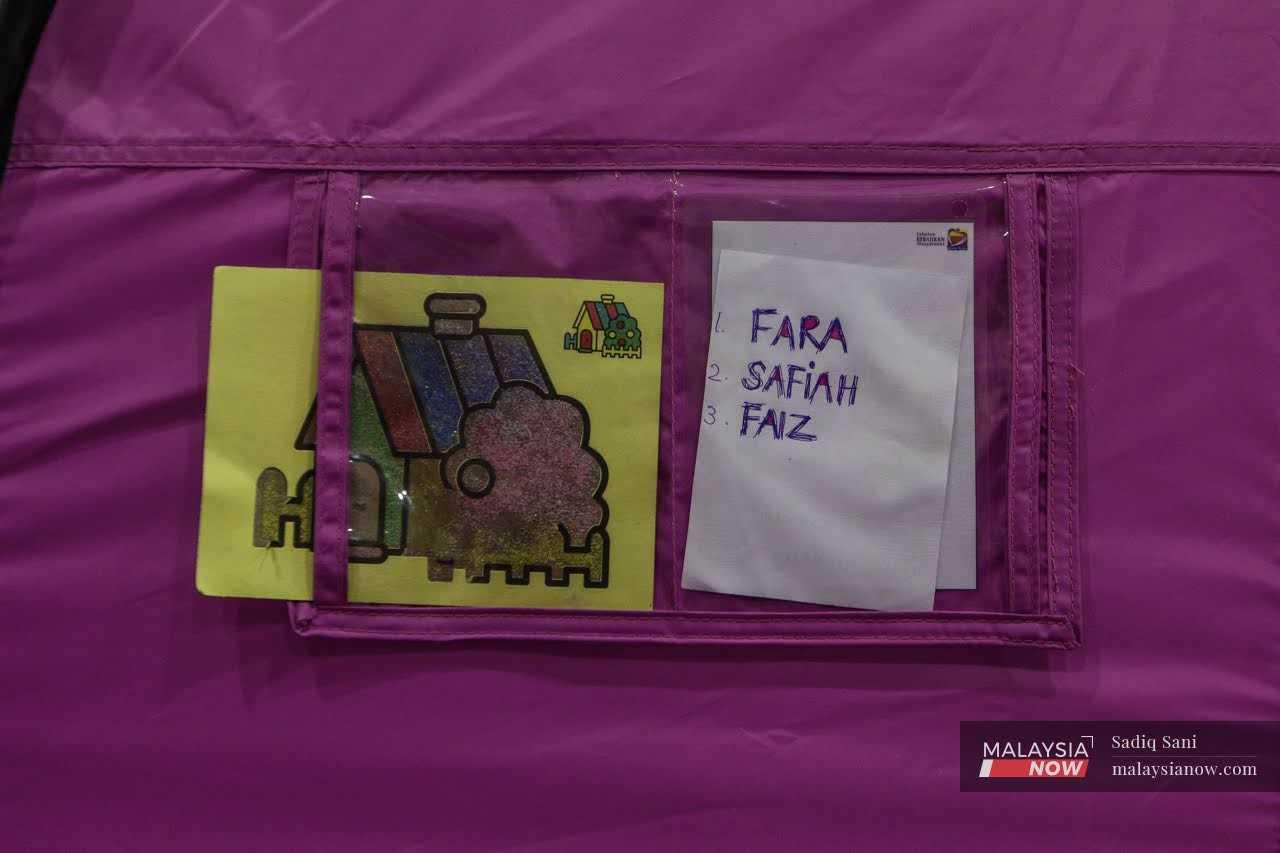 The names of flood victims seen written on a card attached to a tent at an evacuation centre in Kota Tinggi, Johor. 