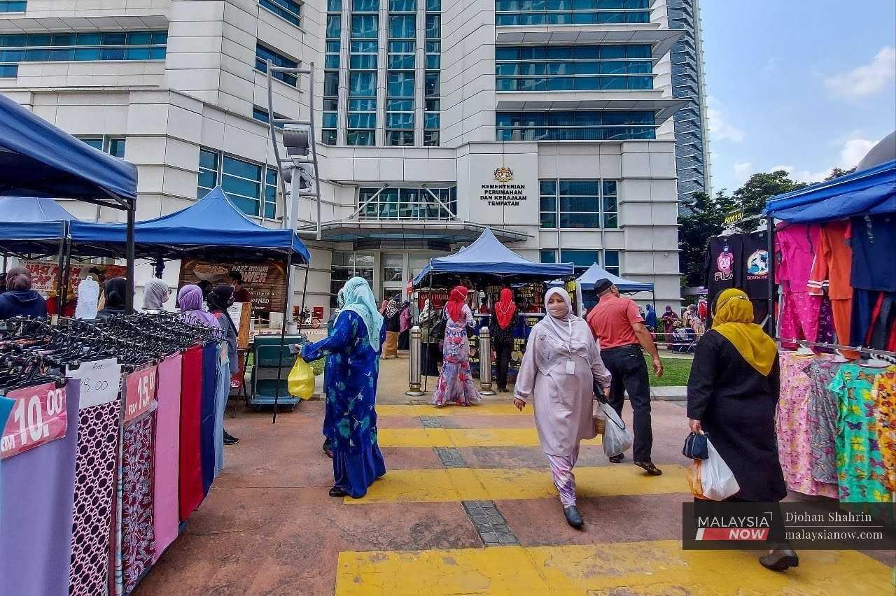 Civil servants on their lunch break browse the stalls set up beside the road near the government complex building in Putrajaya.