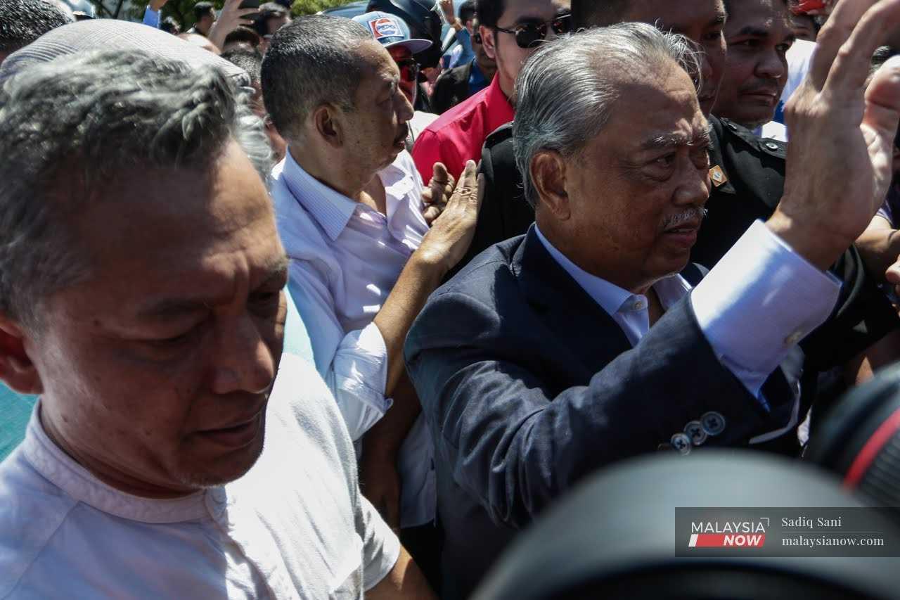 Pengerusi Perikatan Nasional Muhyiddin Yassin melambai ke arah penyokong ketika tiba di Ibu Pejabat SPRM di Putrajaya, pada 11.15 pagi tadi.