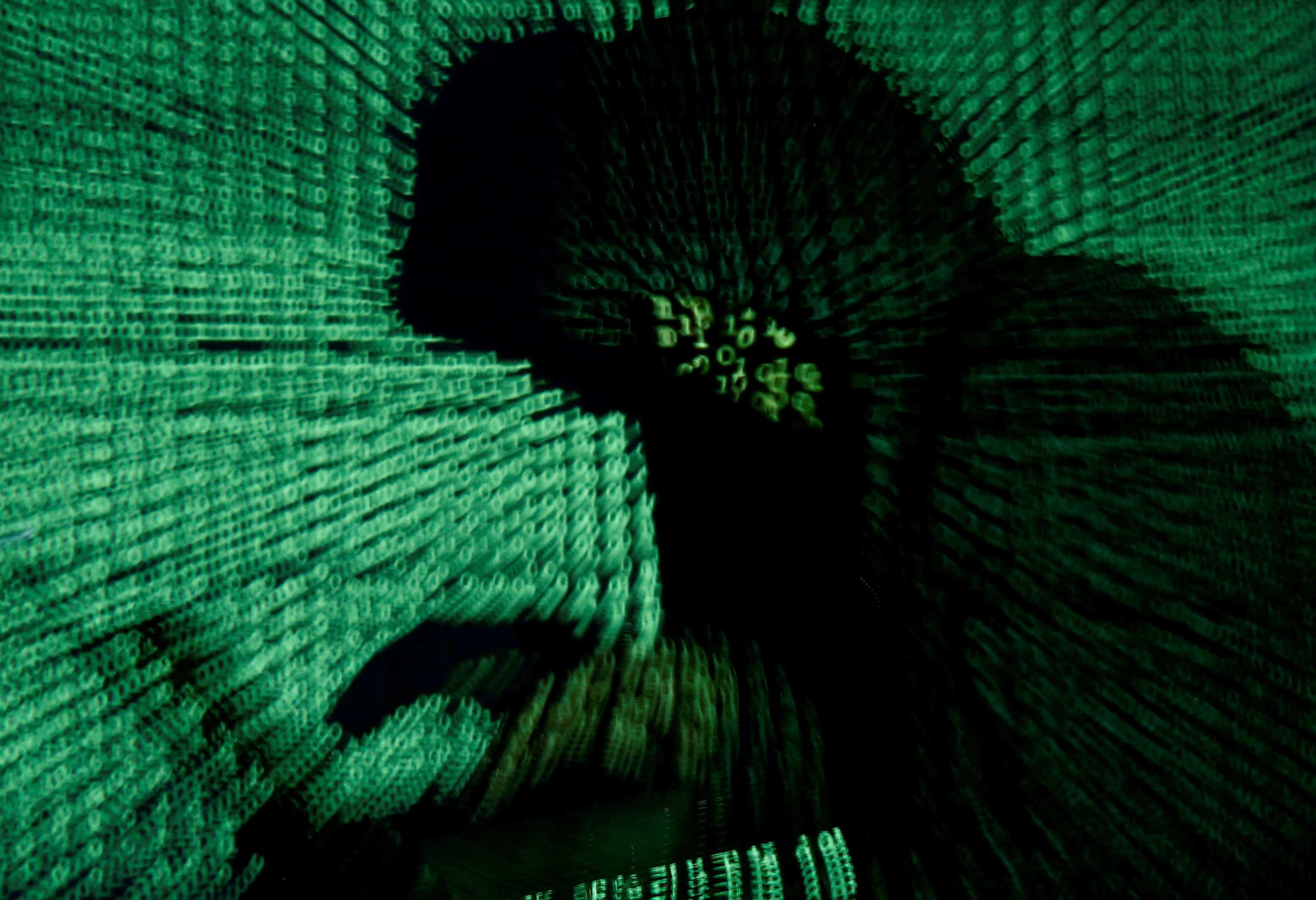 Ilustrasi seorang lelaki memegang komputer riba berlatarbelakangkan kod siber pada 13 Mei 2017. Gambar: Reuters