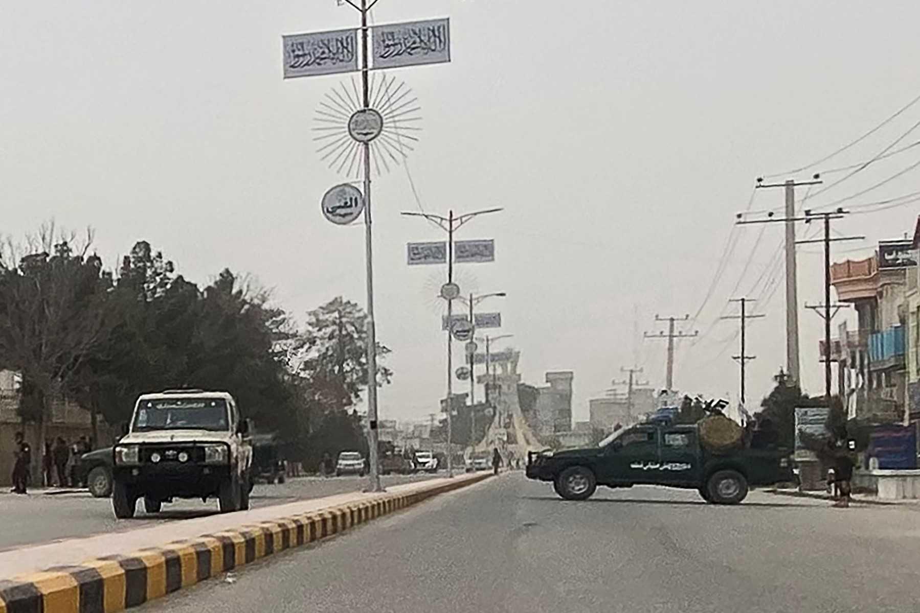 A Taliban security personnel (right) blocks a road in Mazar-i-Sharif, March 8, following a blast at the office of the Taliban governor of the Balkh province. Photo: AFP