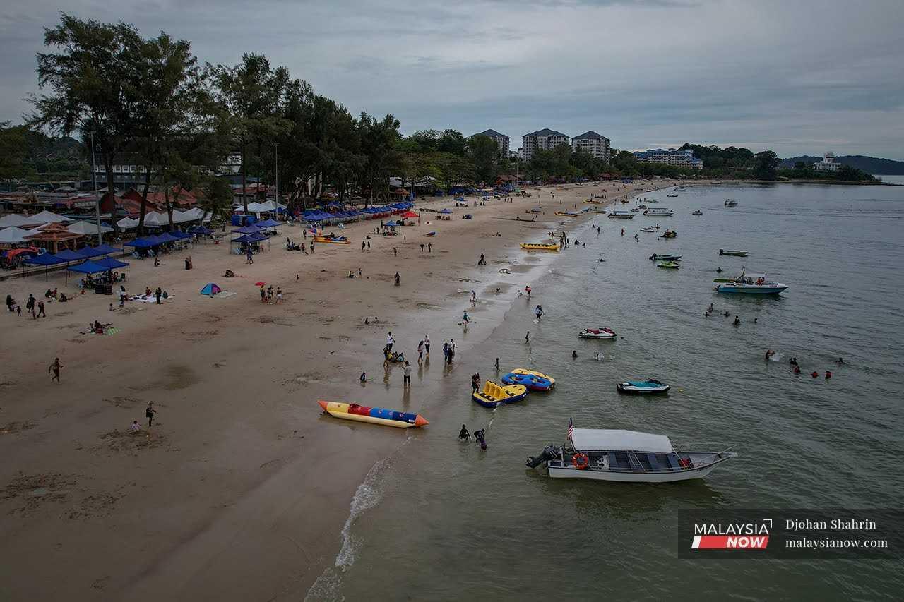 Tourists enjoy a day at the beach at Pantai Teluk Kemang, Port Dickson in Negeri Sembilan. 