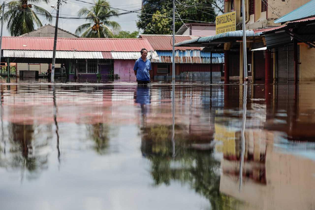 A man looks at the surrounding flood in Parit Sulong, Batu Pahat, March 9. Photo: Bernama