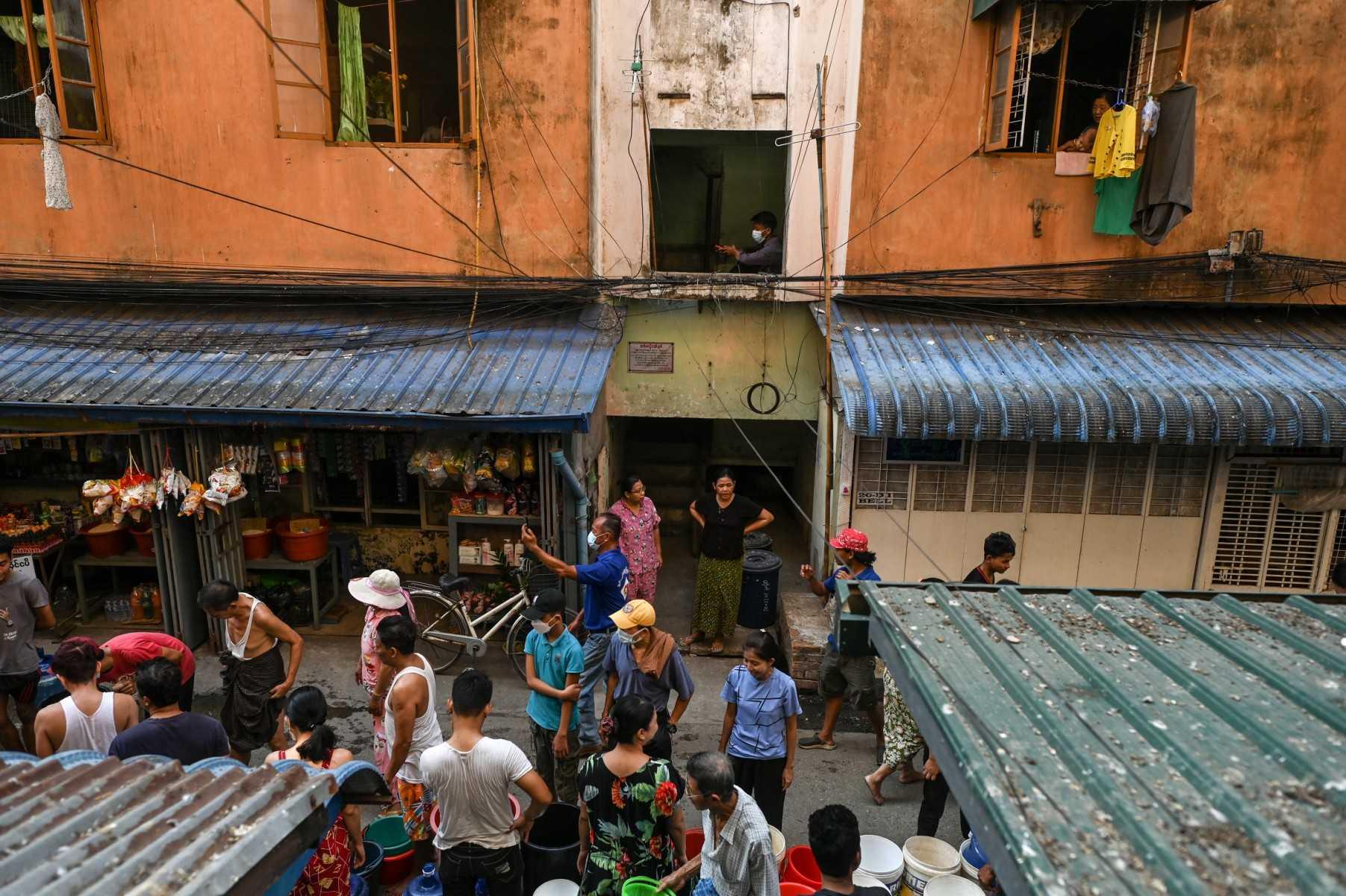 People gather on the street to fill containers with water in Yangon on March 14, 2022. Photo: Reuters