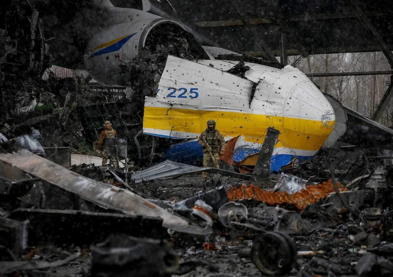 A Ukrainian service member walks in a front of the Antonov An-225 Mriya cargo plane, the world's biggest aircraft, destroyed by Russian troops at an airfield in the settlement of Hostomel, in Kyiv region, April 3, 2022. Photo: Reuters