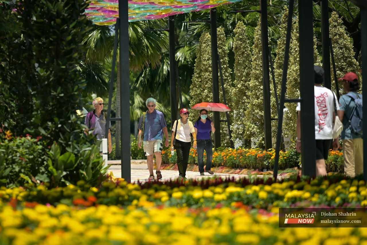 Beberapa pengunjung berjalan kaki sambil melihat pelbagai jenis bunga sempena Festival Kuala Lumpur di Taman Tasik Titiwangsa, 7 Mac.