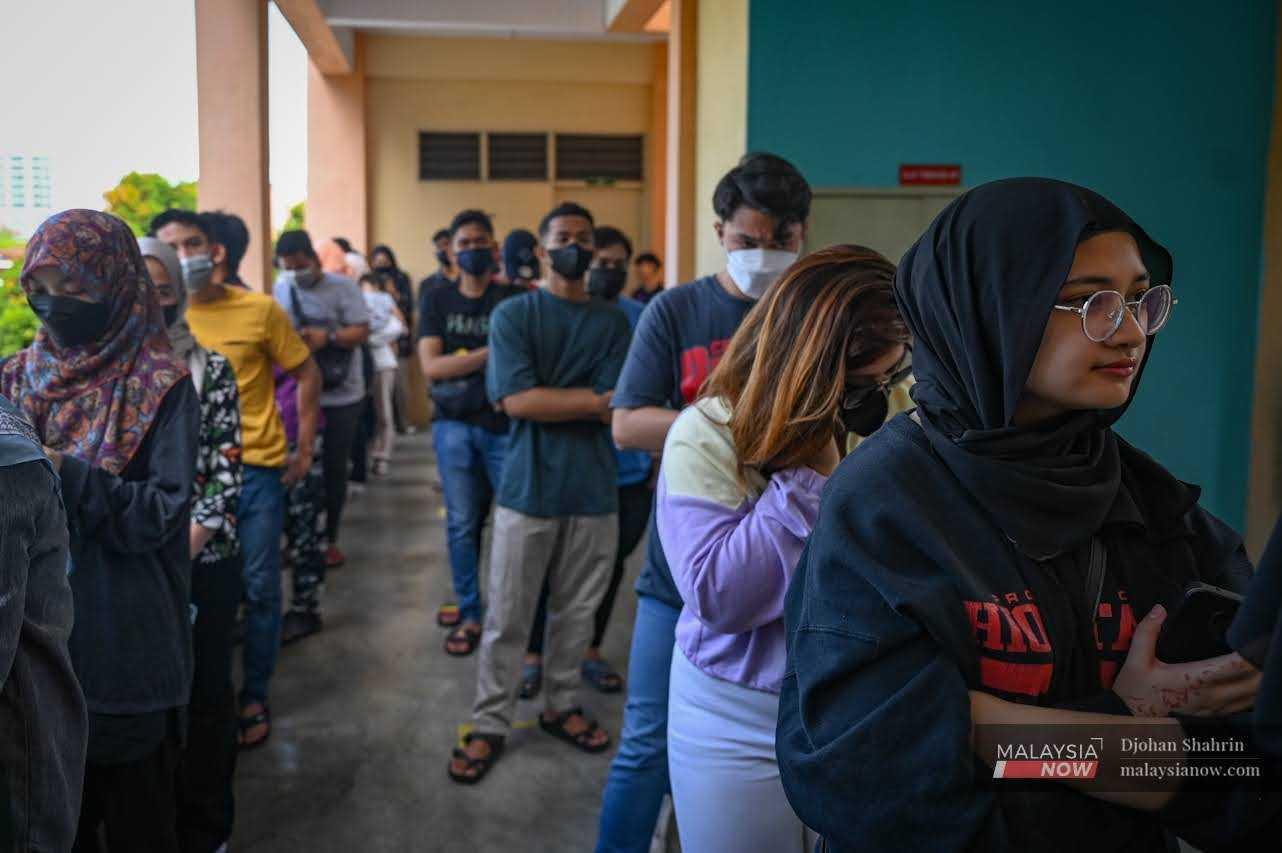 Pengundi muda beratur menunggu giliran untuk masuk ke bilik pengundian di Sekolah Rendah Agama Jalan Raja Muda Musa, Kampung Baru pada 19 November 2022.