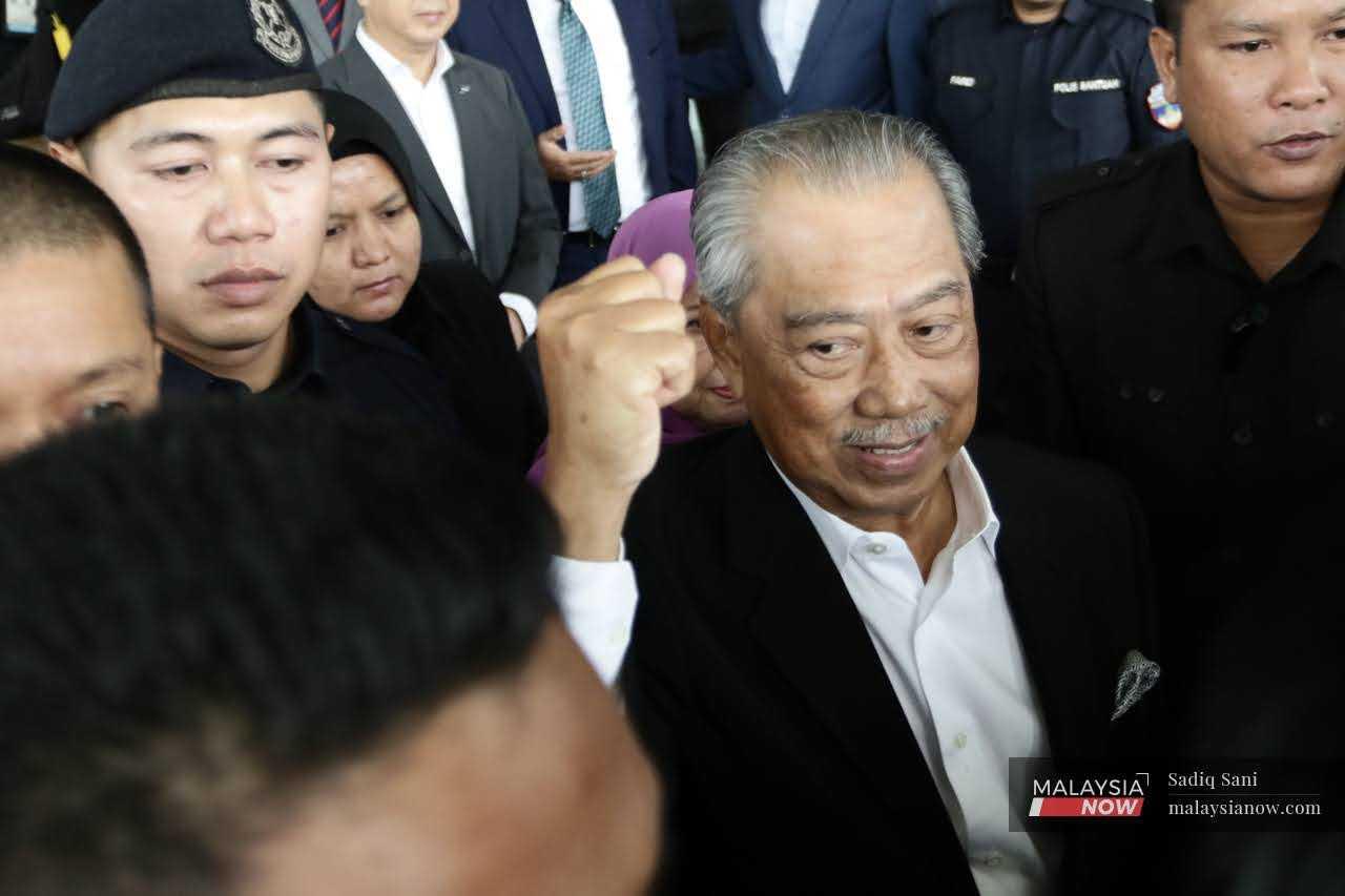 Bekas perdana menteri Muhyiddin Yassin ketika keluar meninggalkan Mahkamah Shah Alam pada 13 Mac.
