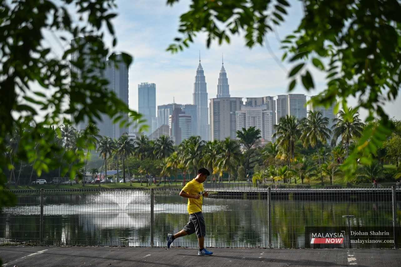 A man jogs past the lake at Taman Tasik Titiwangsa in Kuala Lumpur. 