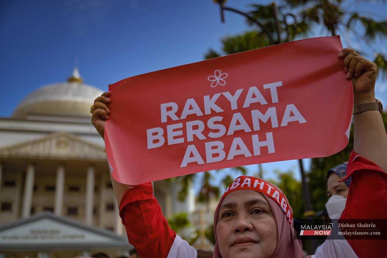 Seorang penyokong mengangkat sepanduk ‘Rakyat Bersama Abah’ di hadapan Mahkamah Kuala Lumpur pada 10 Mac lalu. Pengerusi Perikatan Nasional, Muhyiddin Yassin didakwa atas beberapa pertuduhan berkaitan kes JanaWibawa.