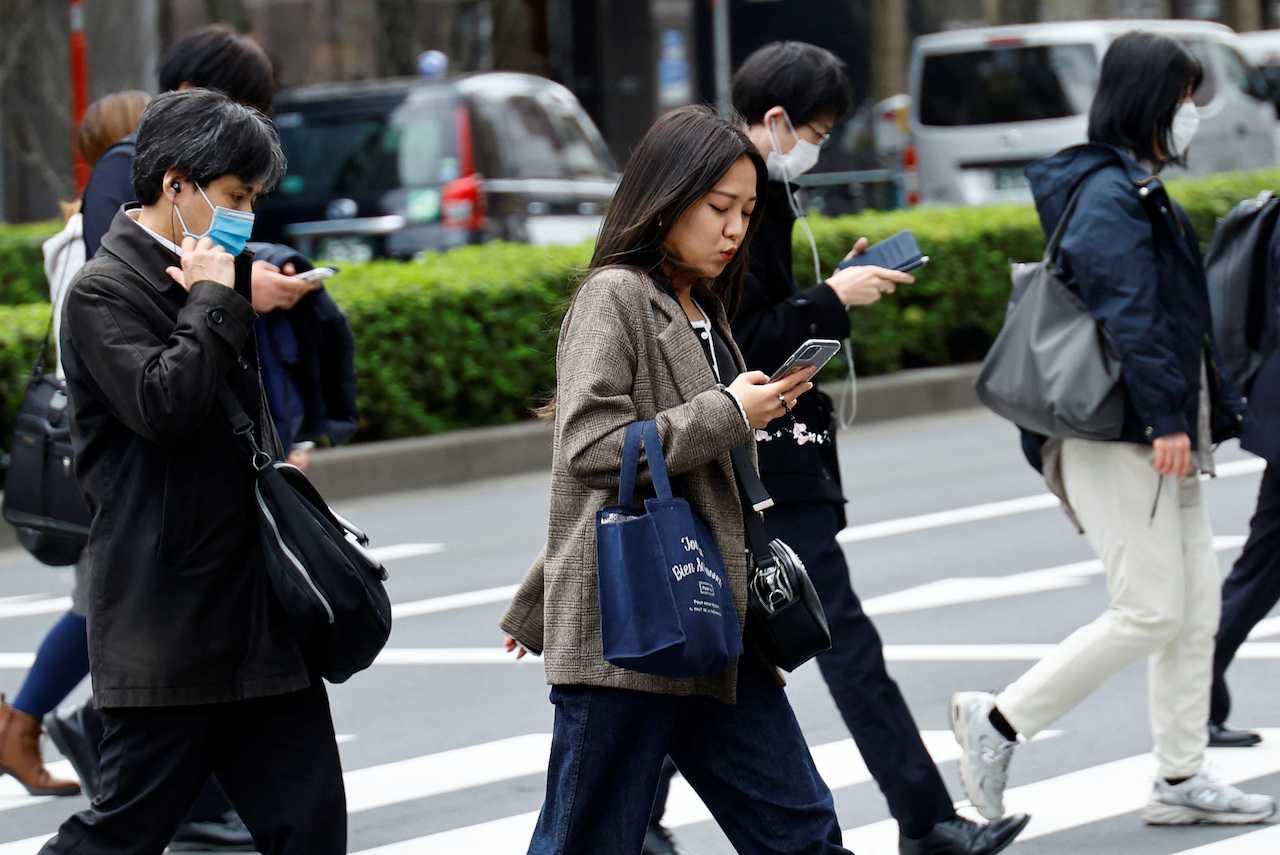 Commuters make their way on the first day of the government's relaxation of official guidance on masks as it emerges from the Covid-19 pandemic, in Tokyo, Japan, March 13. Photo: Reuters