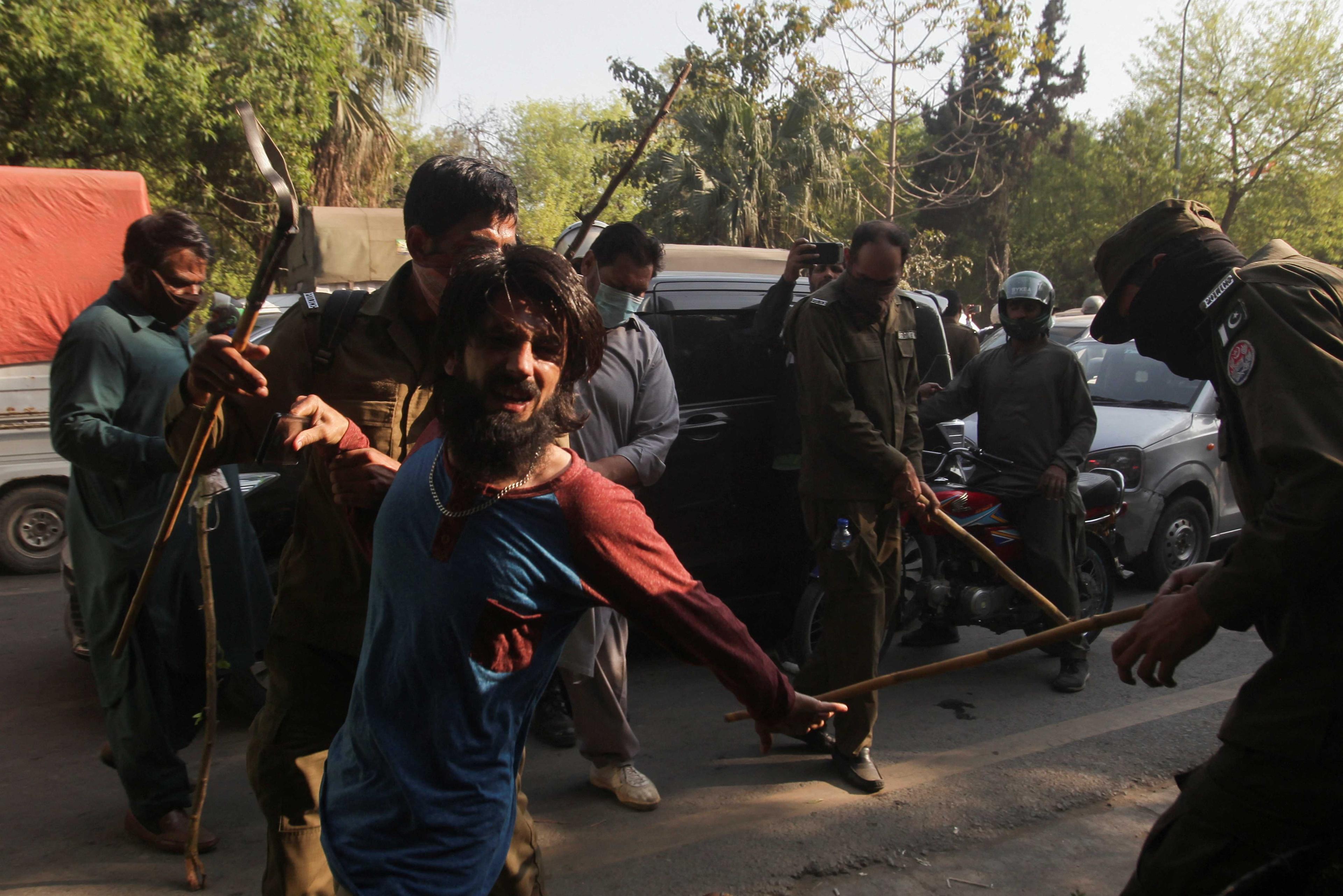 Police officers detain a supporter of former Prime Minister Imran Khan, during clashes ahead of an election campaign rally, in Lahore, Pakistan March 8. Photo: Reuters